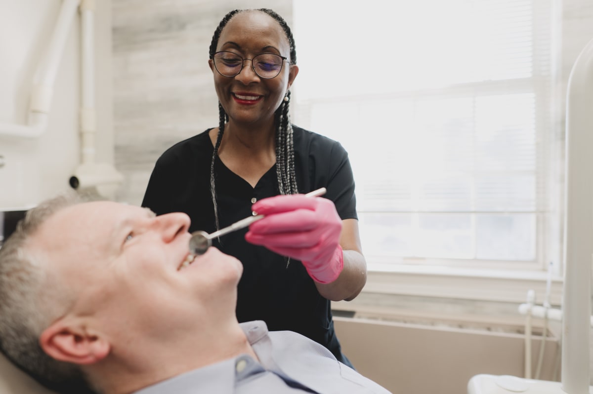 Dentist examining a patient's smile during a consultation at the practice