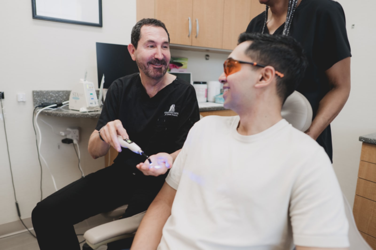 Dentist showing veneer samples to a patient during a treatment consultation