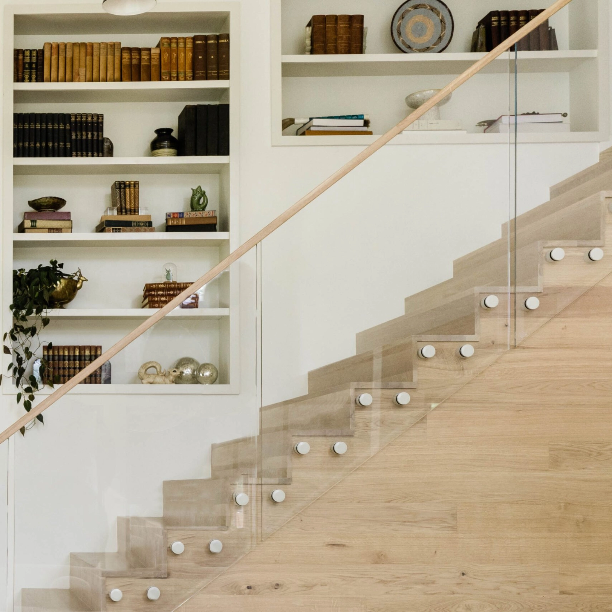 Standoff Pins on a traditional staircase in front of built-in bookshelves