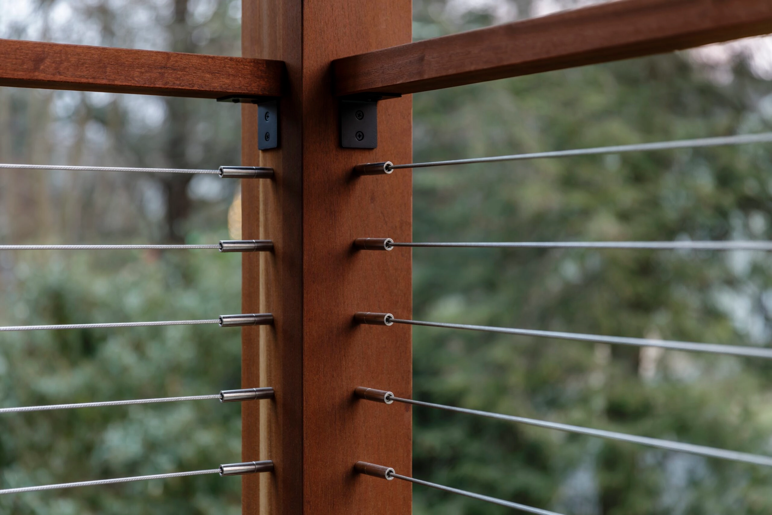 Cable lines converge on a wood corner post fitted with black DriveTite hardware