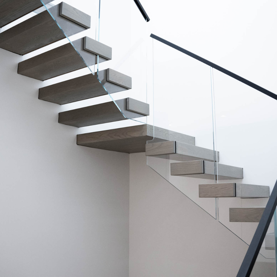 Render of cantilevered treads behind a glass railing on a white wall