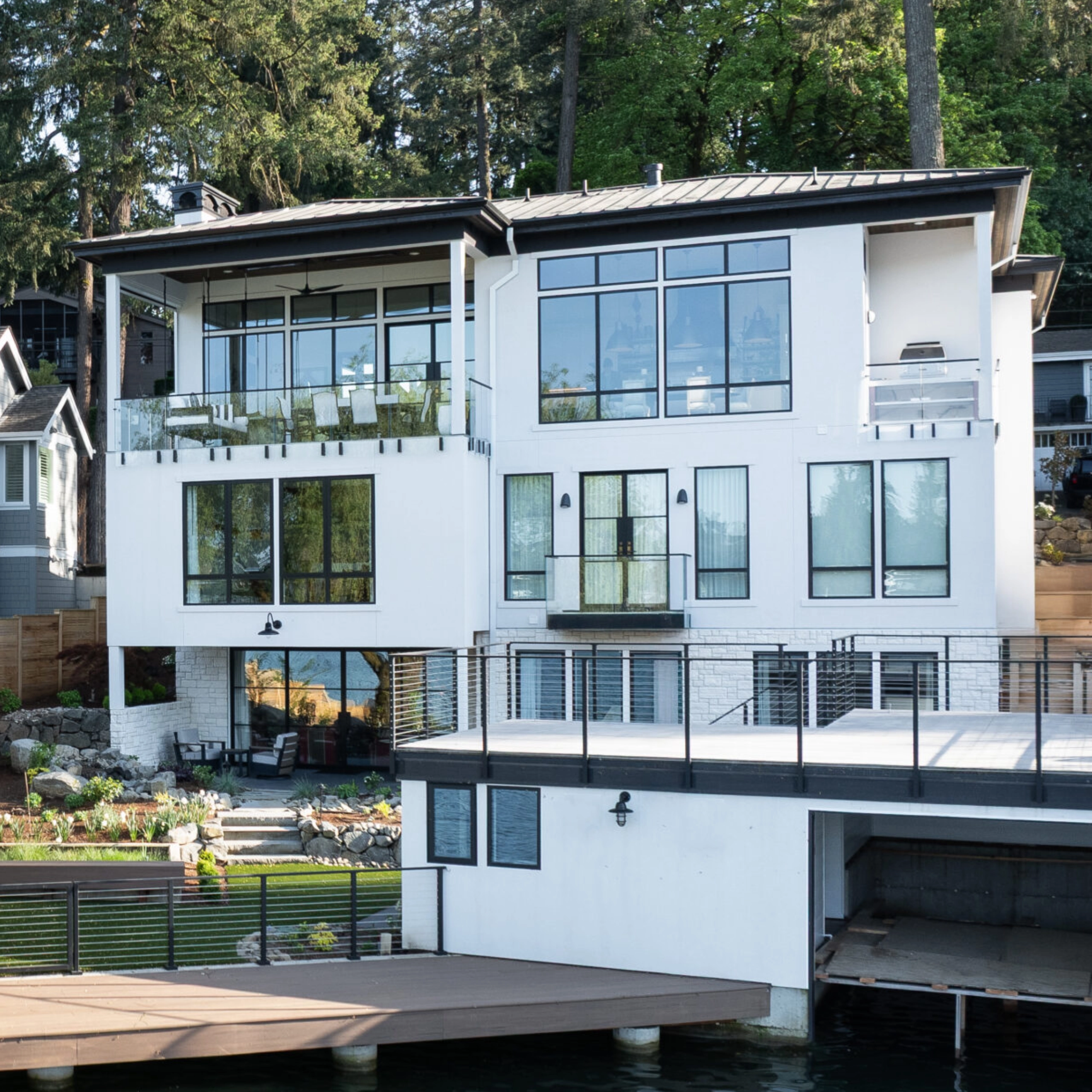 A three-level lakefront home carries glass railings on each of its balconies