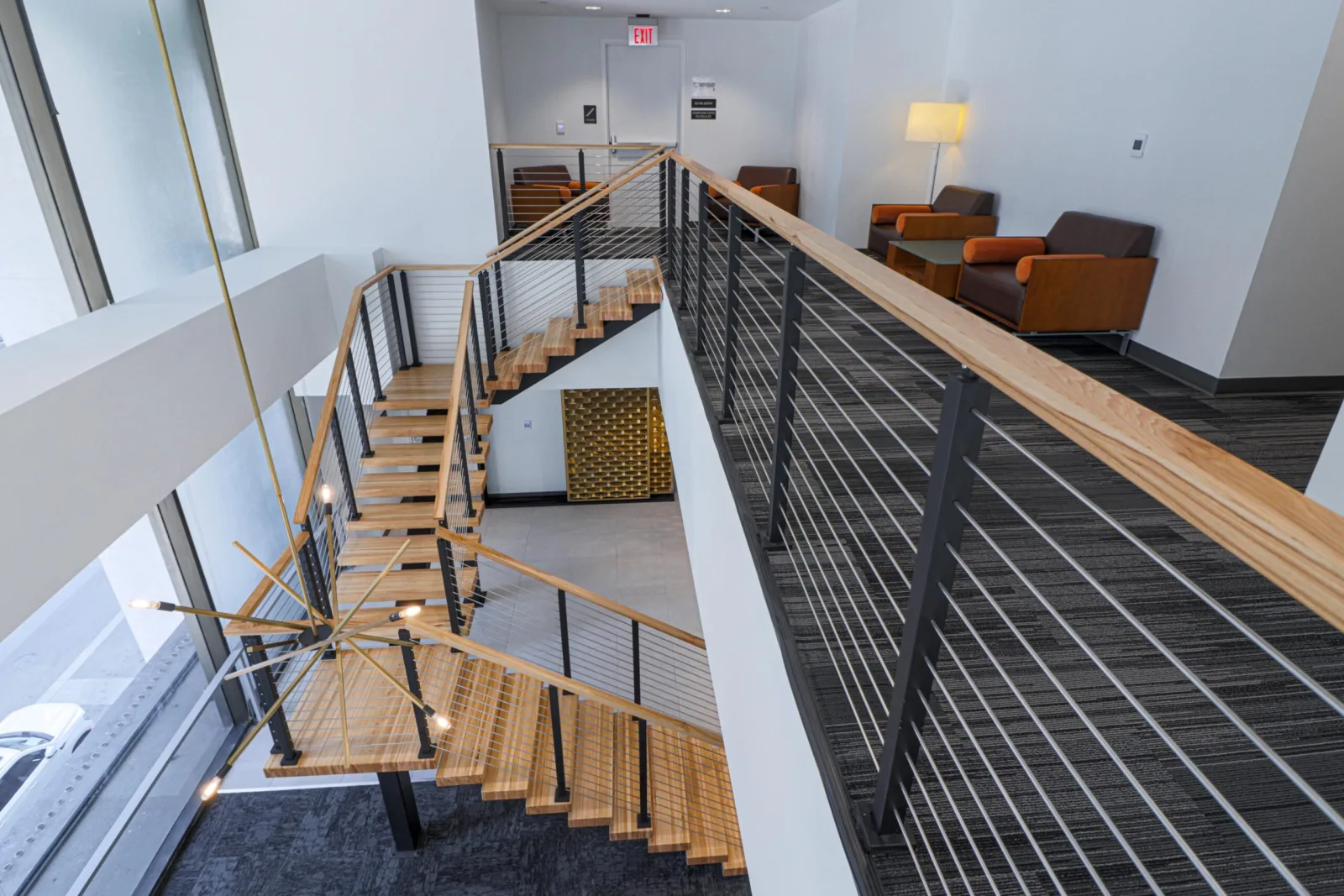Stair with wood treads seen from above beside a lounge seating area