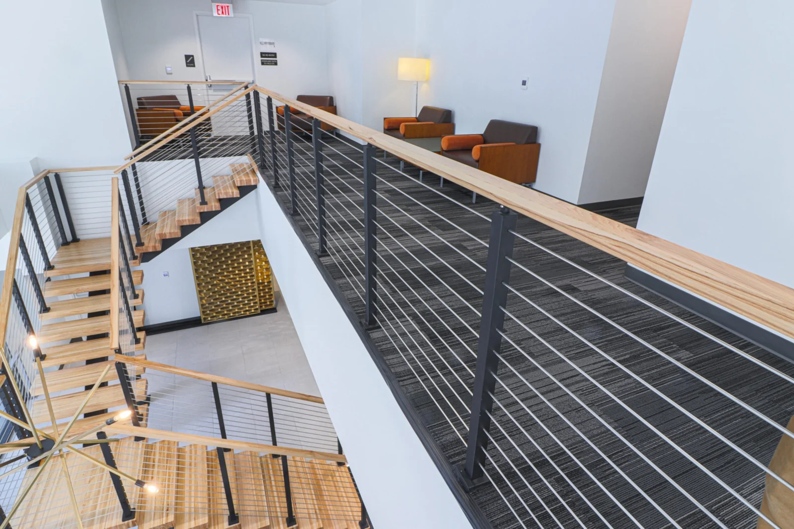 Elevated view of the flight descending past the railing toward the lounge