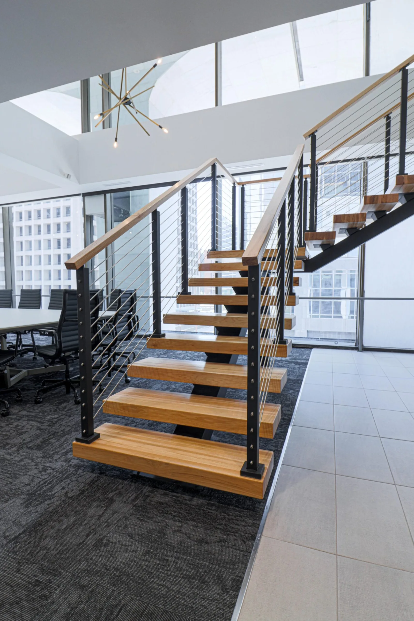 Stair rising from tile to carpet with conference seating to the left