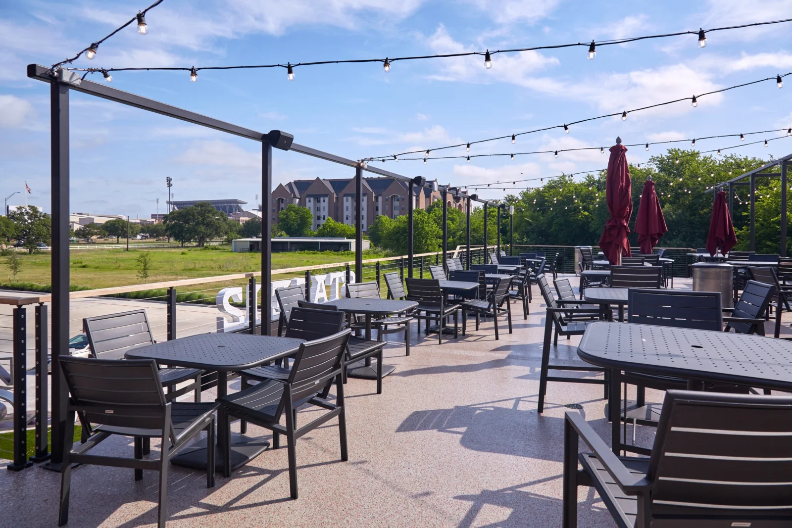 Patio seating with string lights and cable railing enclosing the raised terrace edge