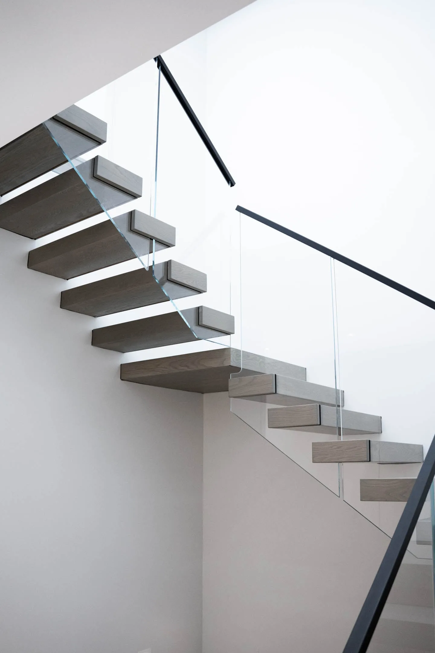 Underside of the cantilevered flight stepping up a bright white wall