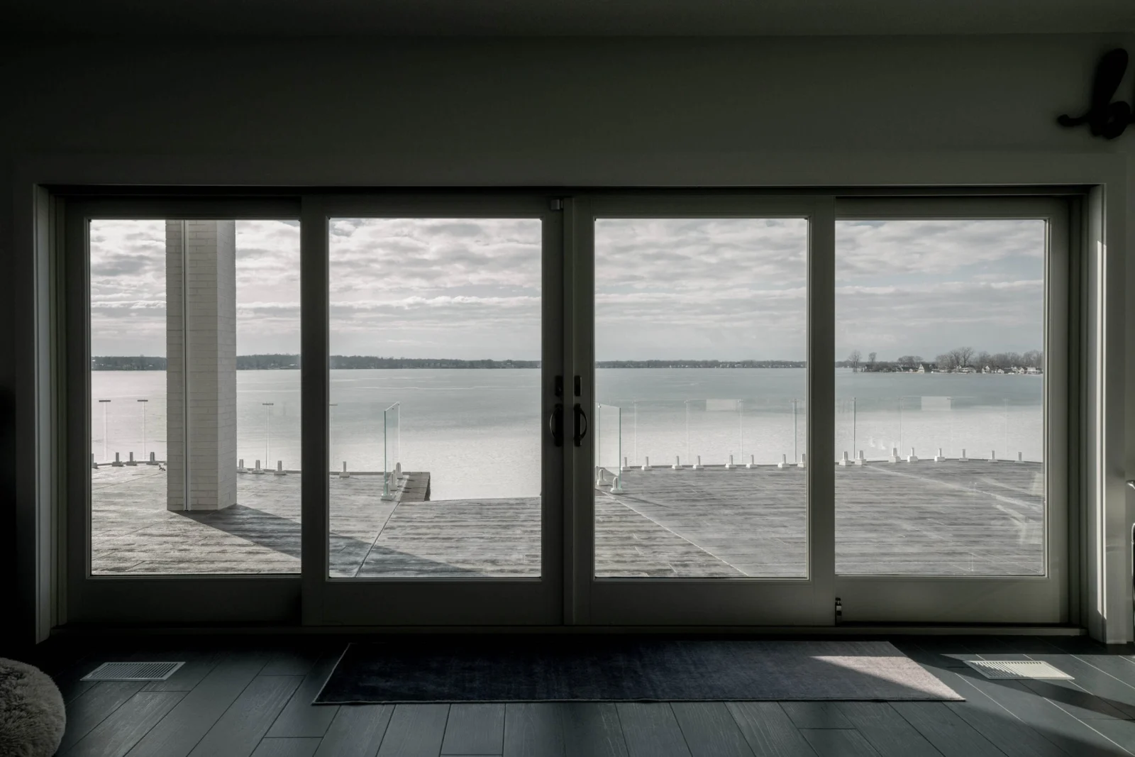 View from inside through sliding doors to the glass-railed terrace beyond