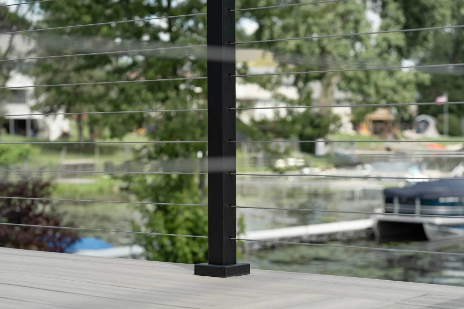 Black post and cable lines against a marina of docked pontoon boats