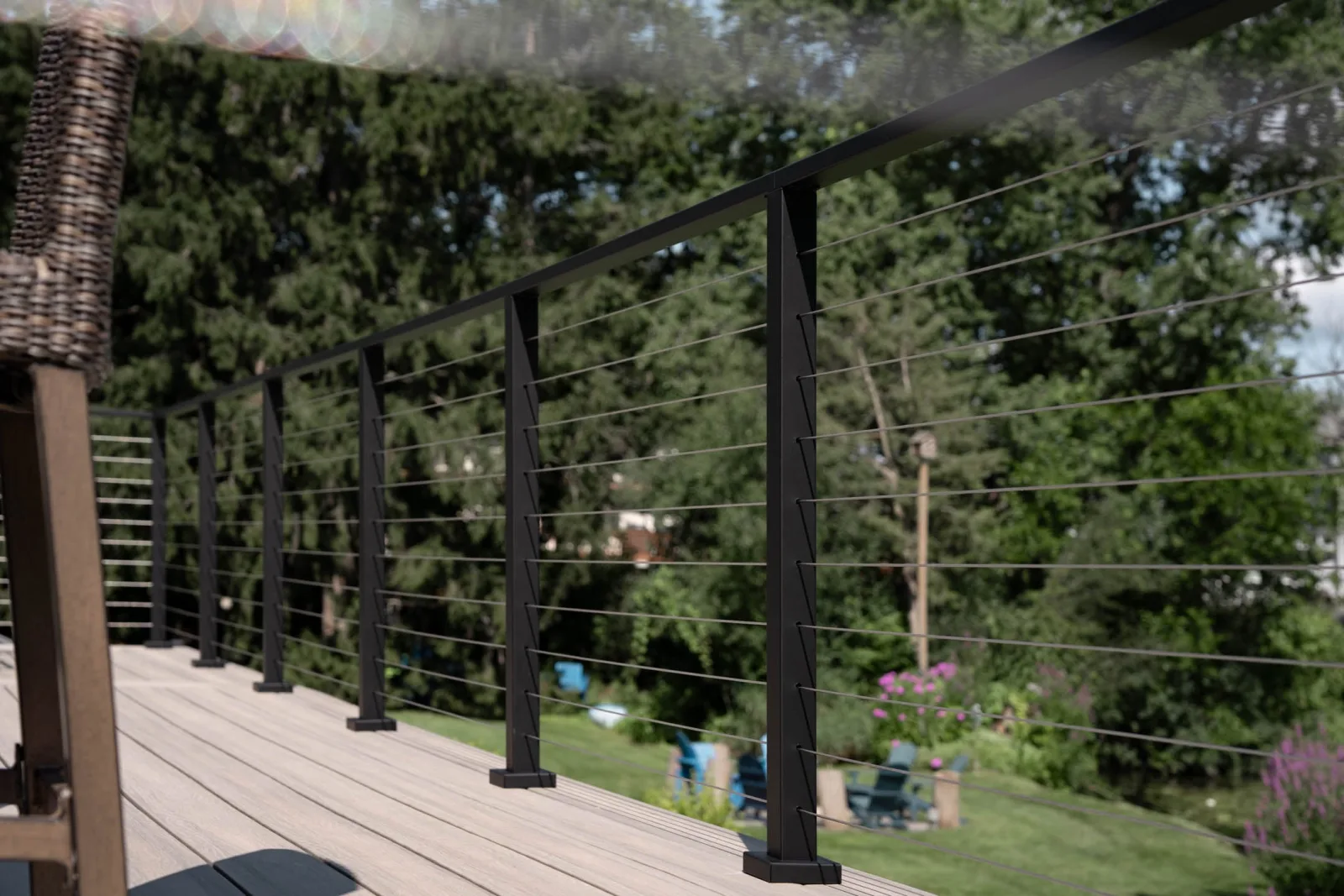 Row of black posts running along the deck edge above a garden