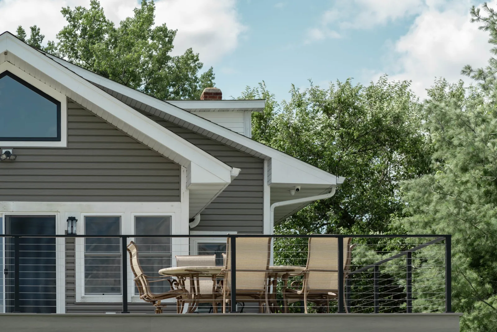 Gabled roofline above the railing with seating arranged along the deck