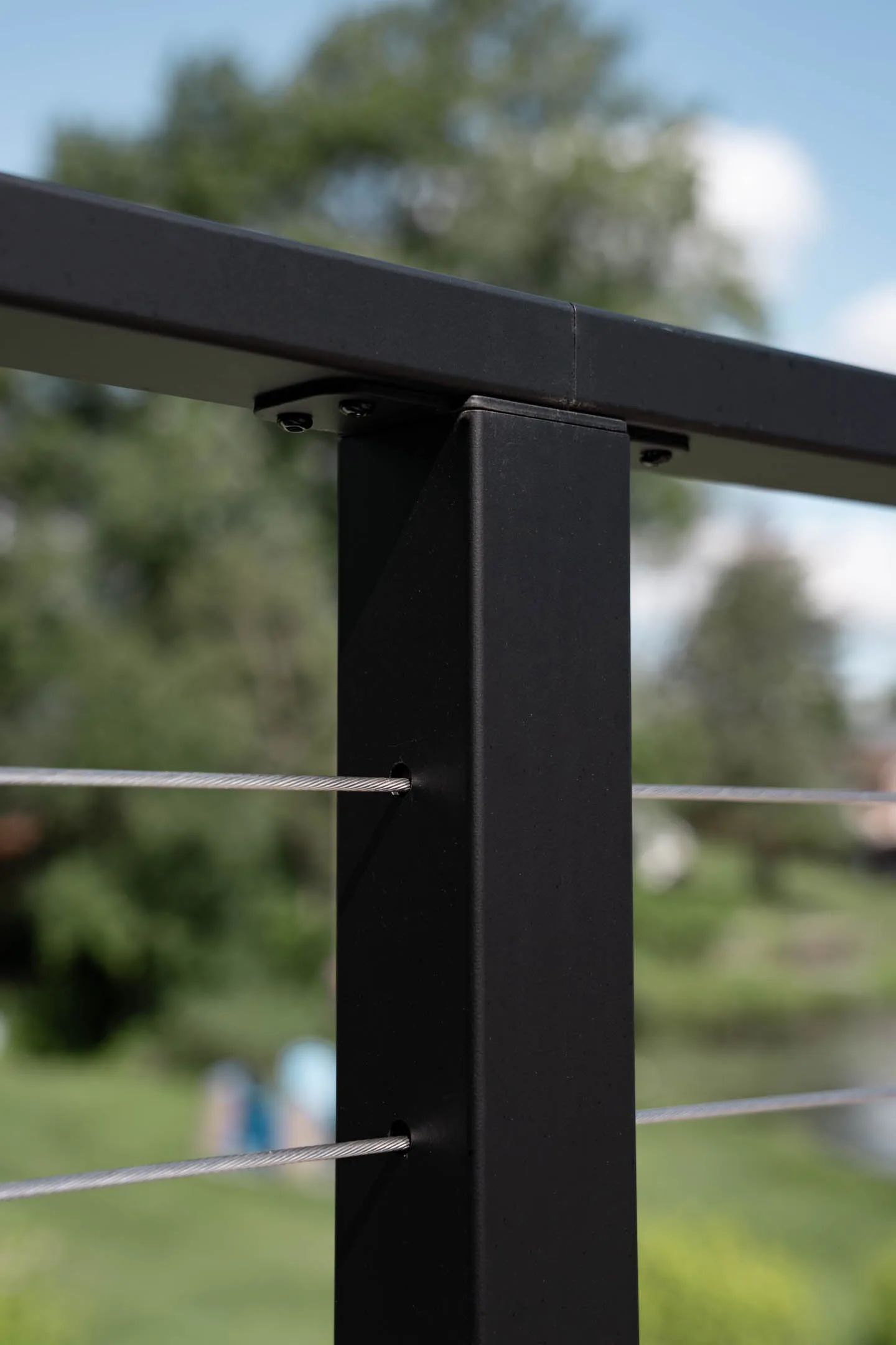 Detail of a black post seated beneath the flat top rail