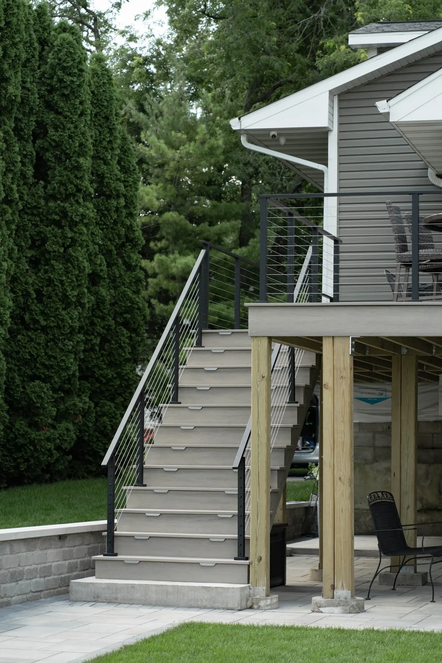 Composite stairs climbing to the raised deck with cable railing both sides