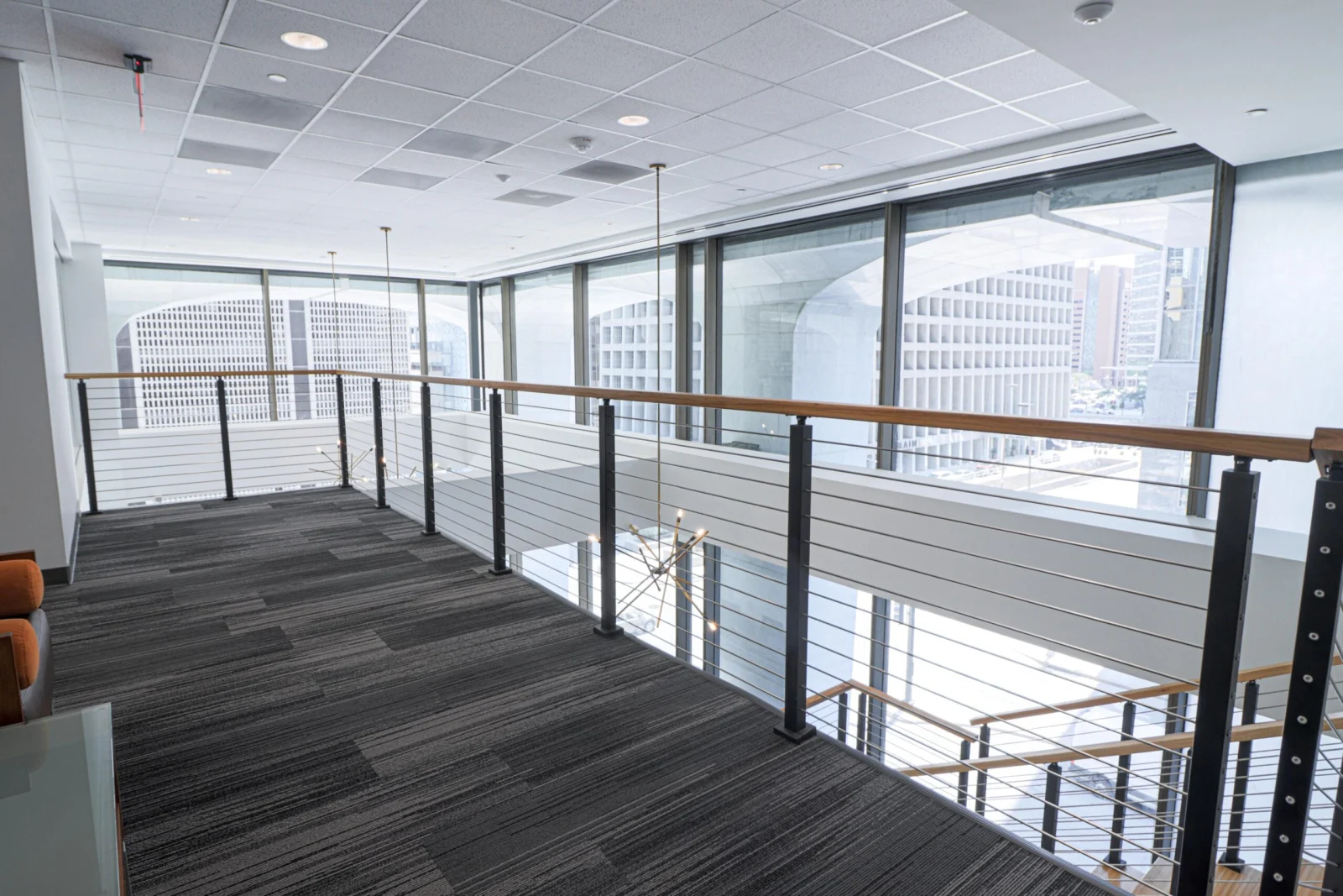 Wide view of the balcony run with city towers through floor-to-ceiling glass