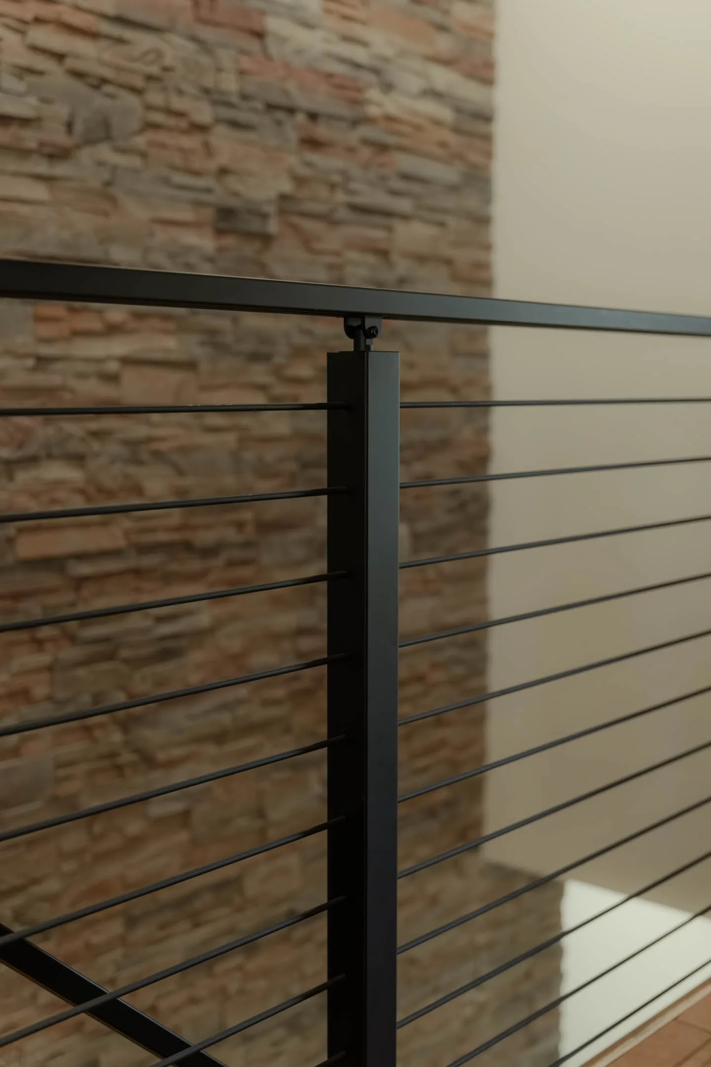 Close view of a black post joining the top rail above horizontal metal rods