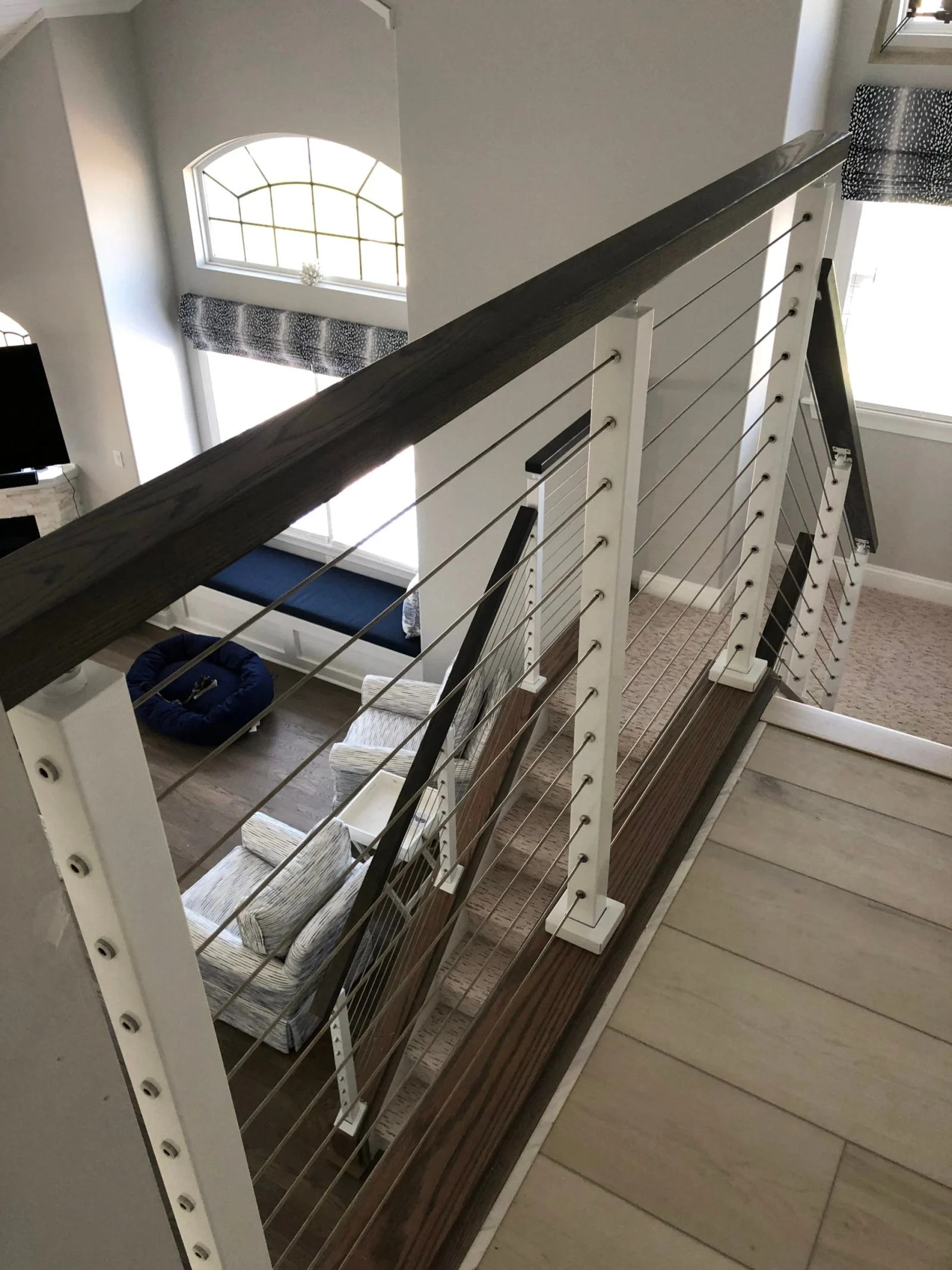 Looking down over the balcony rail at the room below with cables