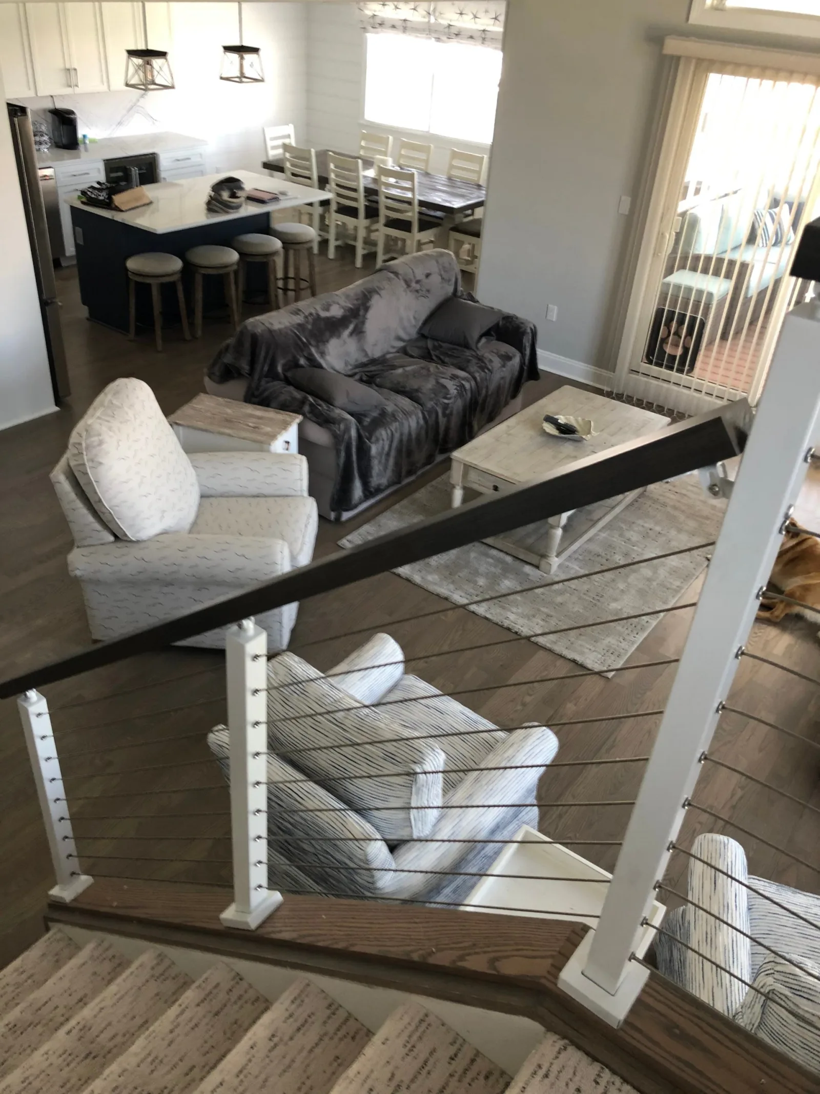 View from the upper landing into the living room across the cable railing