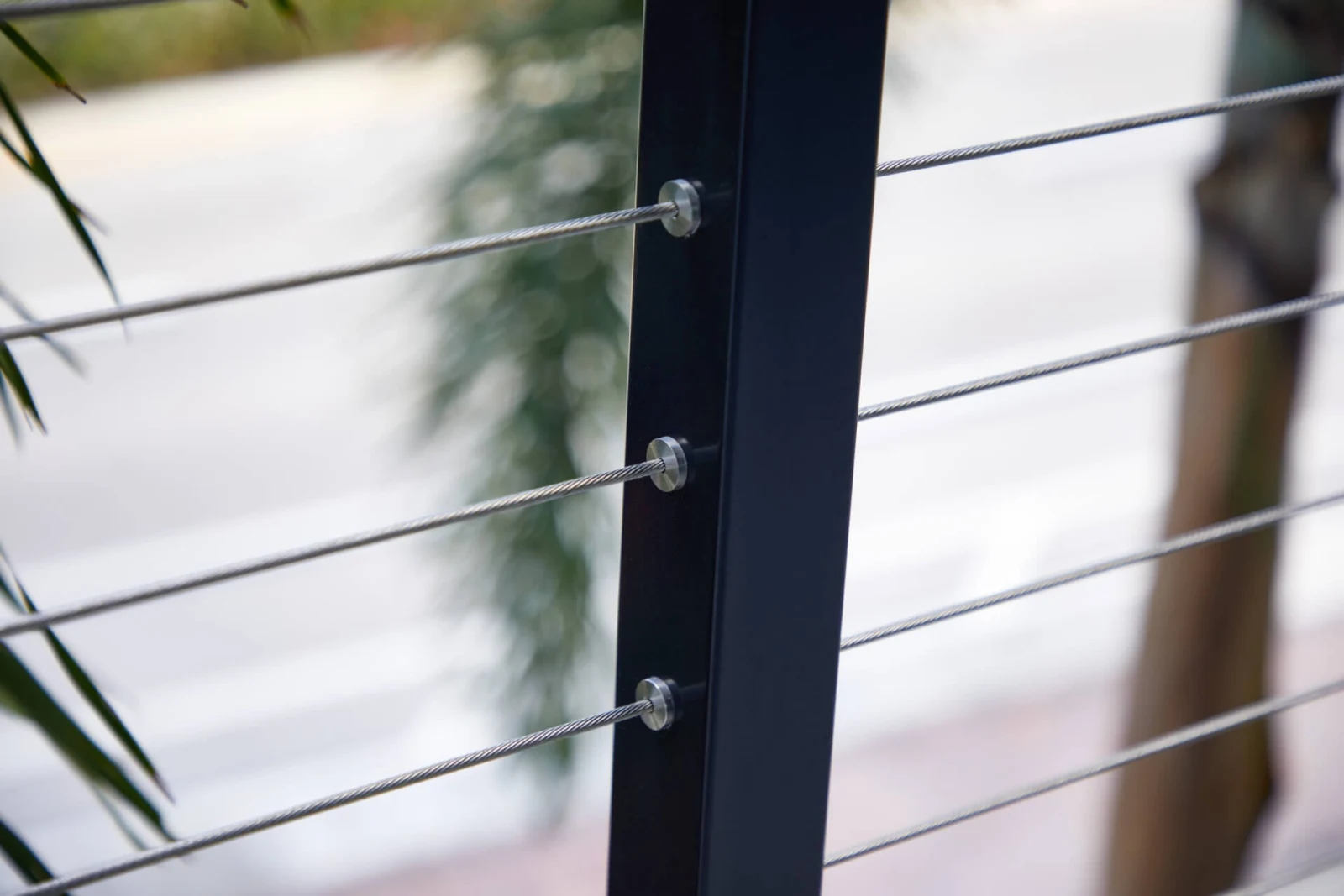 Cable end fittings threaded through a black post in tight close view