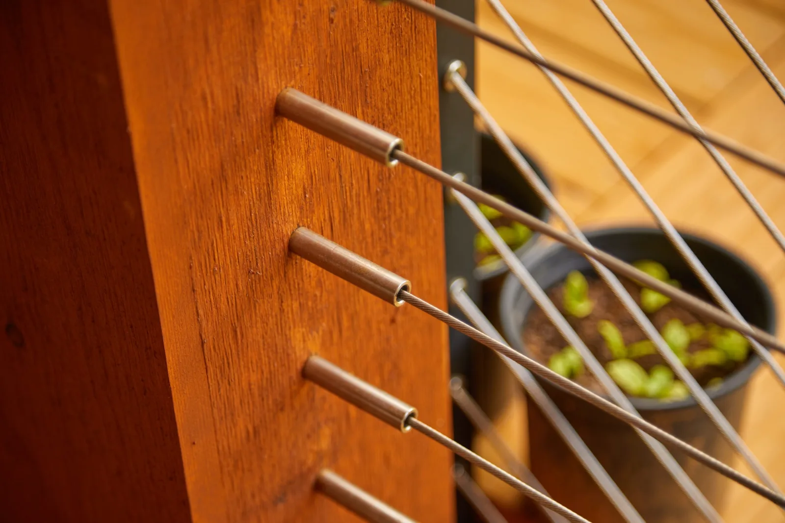 Close view of cable ends fastened through a stained wood post