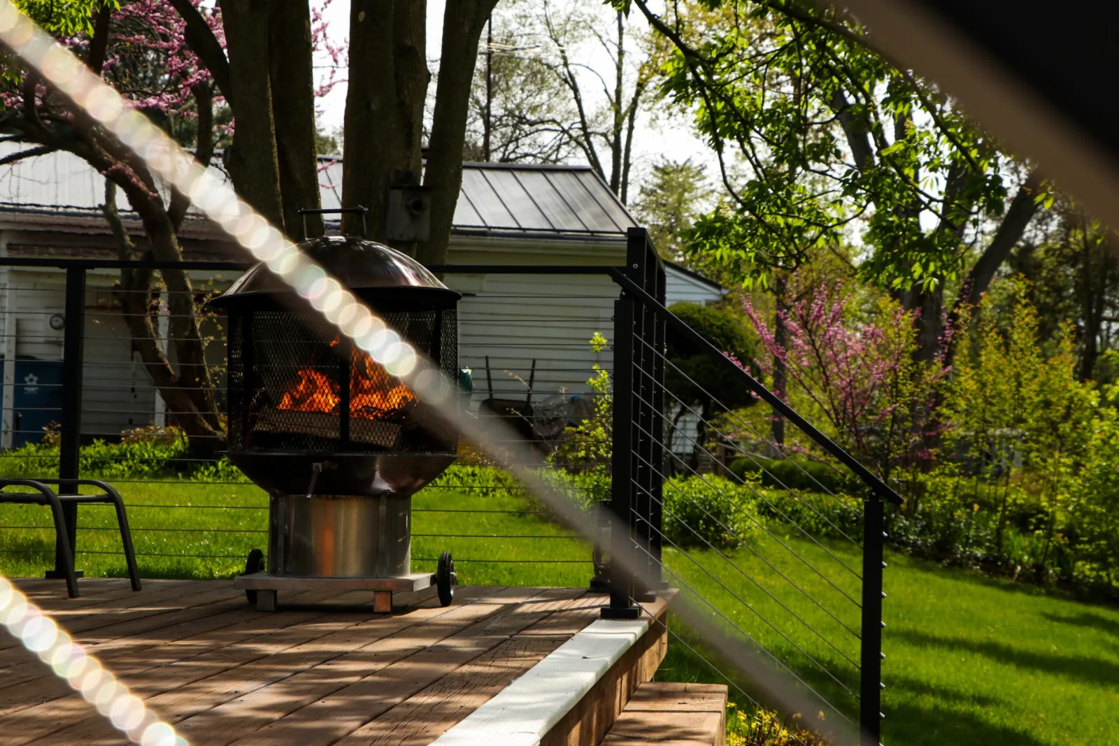Cables in the foreground with a lit fire bowl on the deck behind