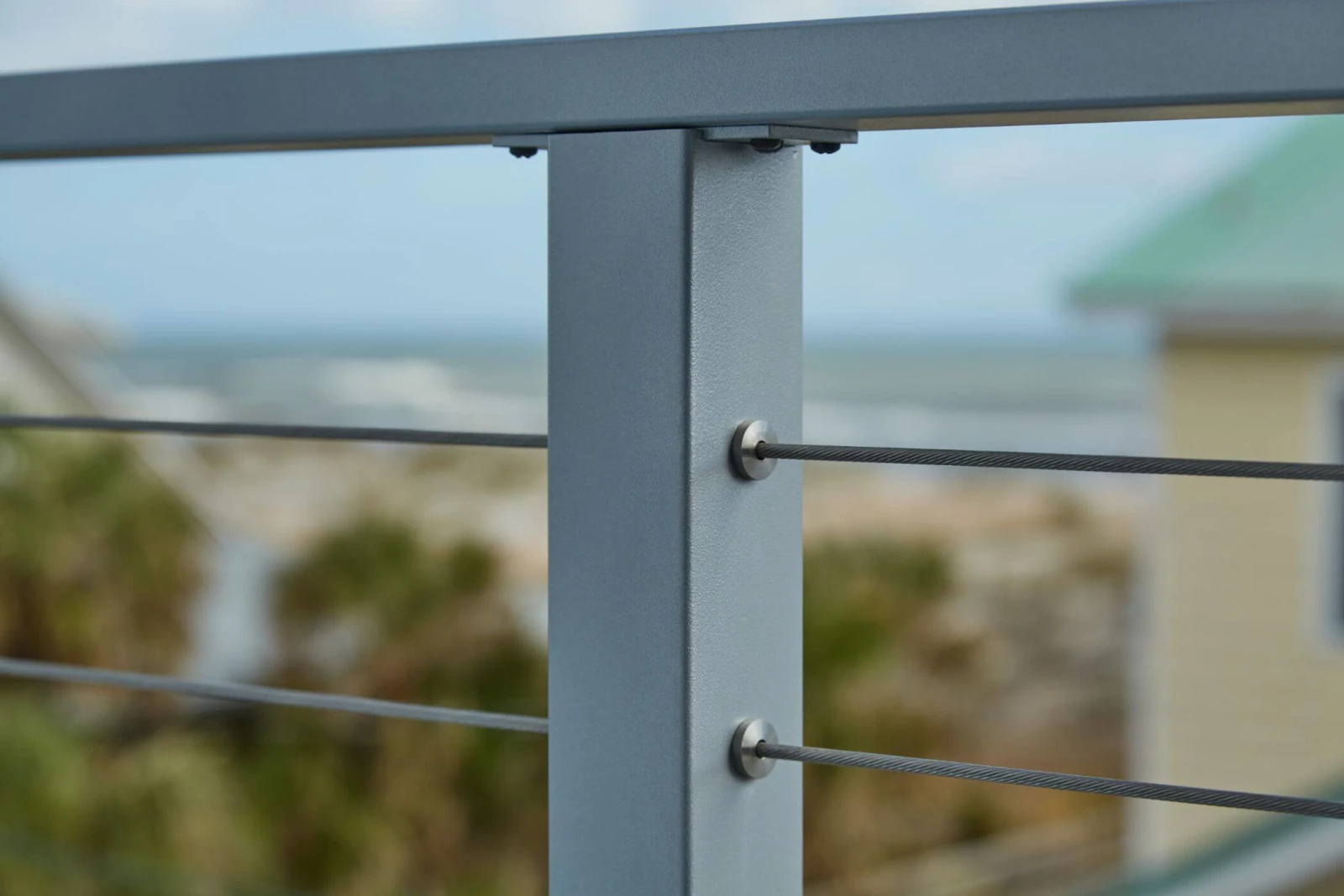 Close view of cable fittings in a gray post below a flat top rail