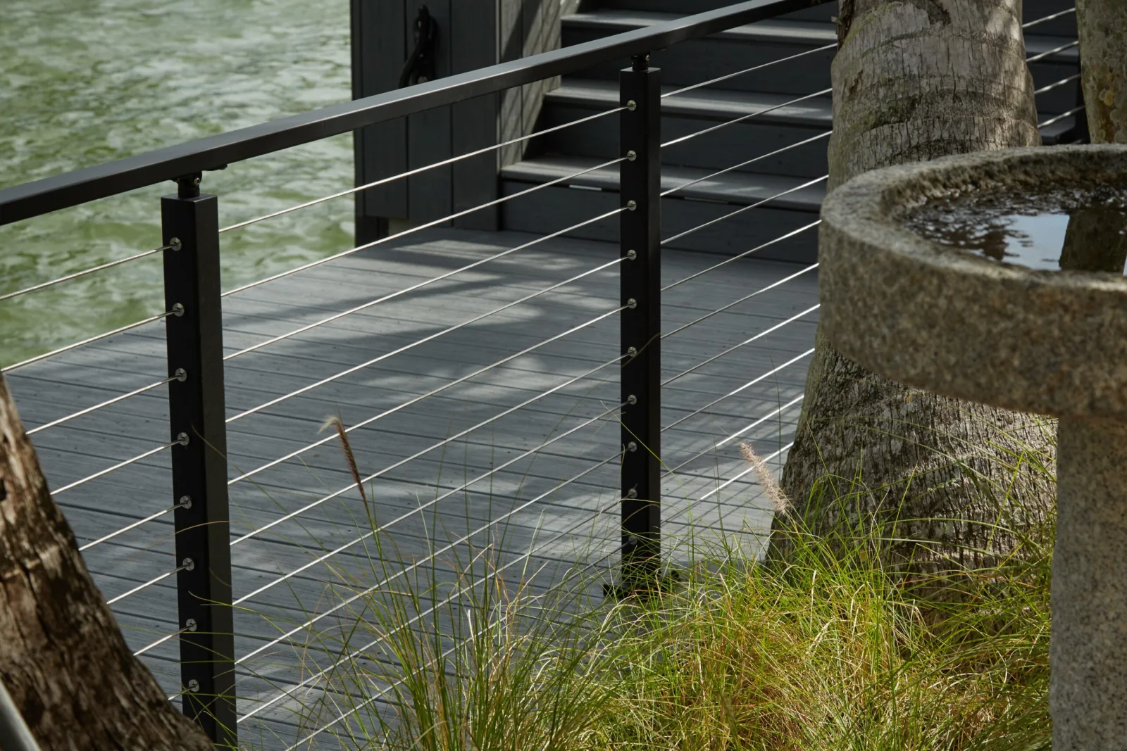 Black posts and taut cables at the deck edge above the waterway