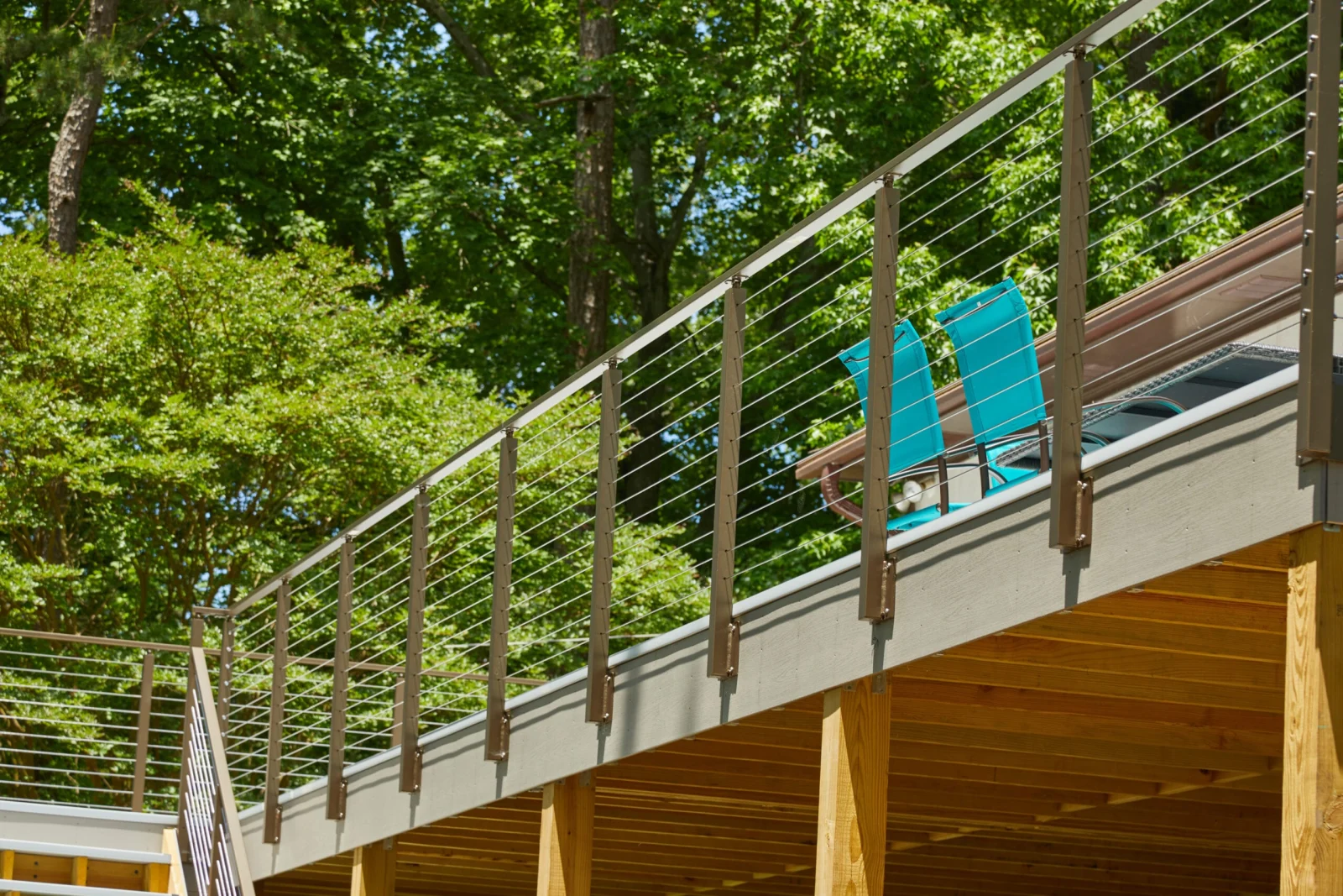 Raised deck seen from the yard, dark posts and cables above timber framing