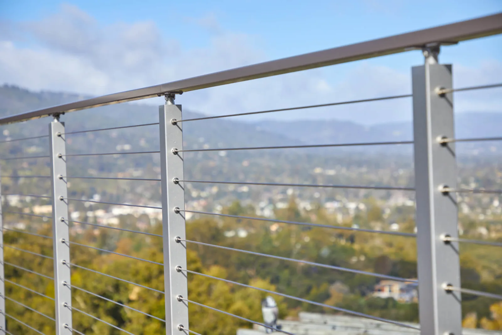 Detail of the top rail curving away over evenly spaced cables