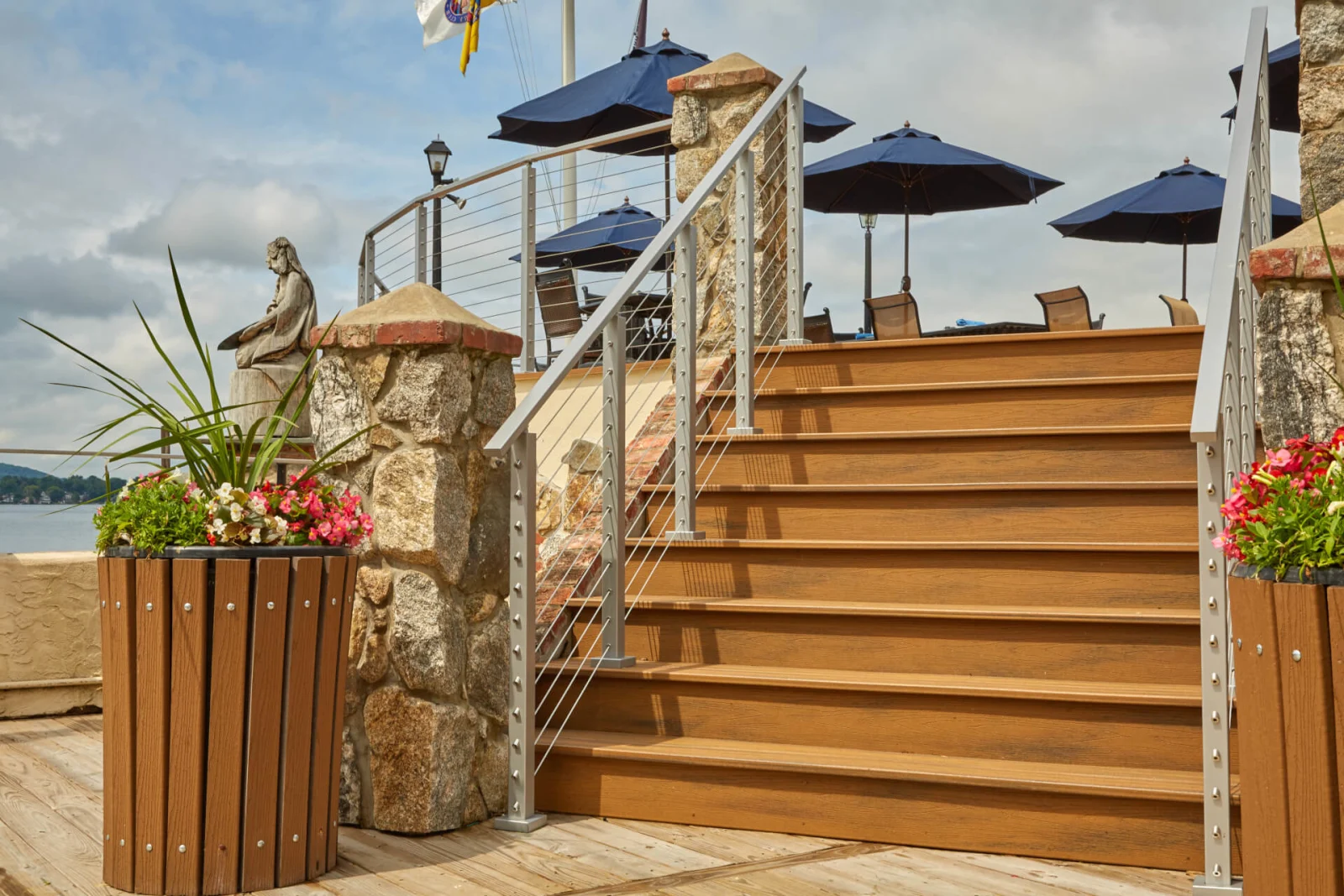 Angled stair view with planters, patio umbrellas and a lake beyond