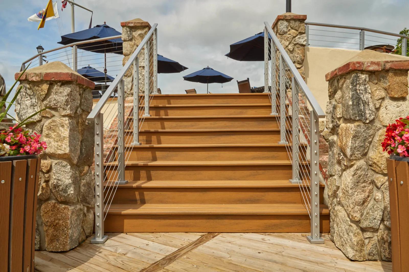 Head-on view of stairs framed by stone columns and cable railing runs