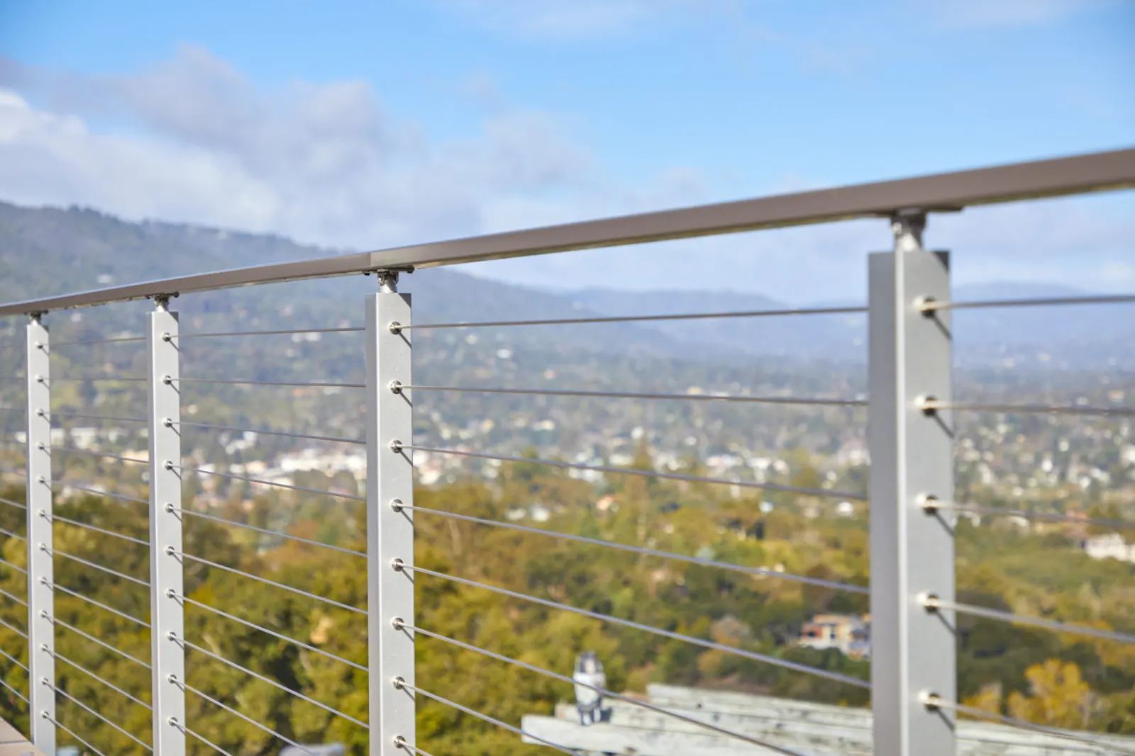 Sunlit posts and cable ends in sharp focus with the town blurred behind