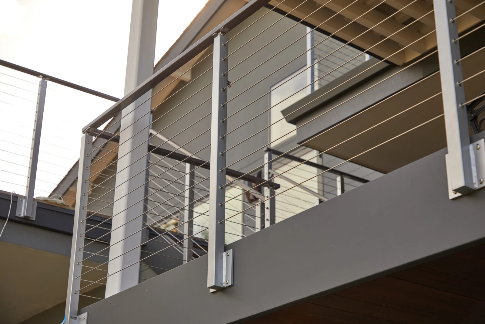 Upward view of deck framing with railing posts rising overhead
