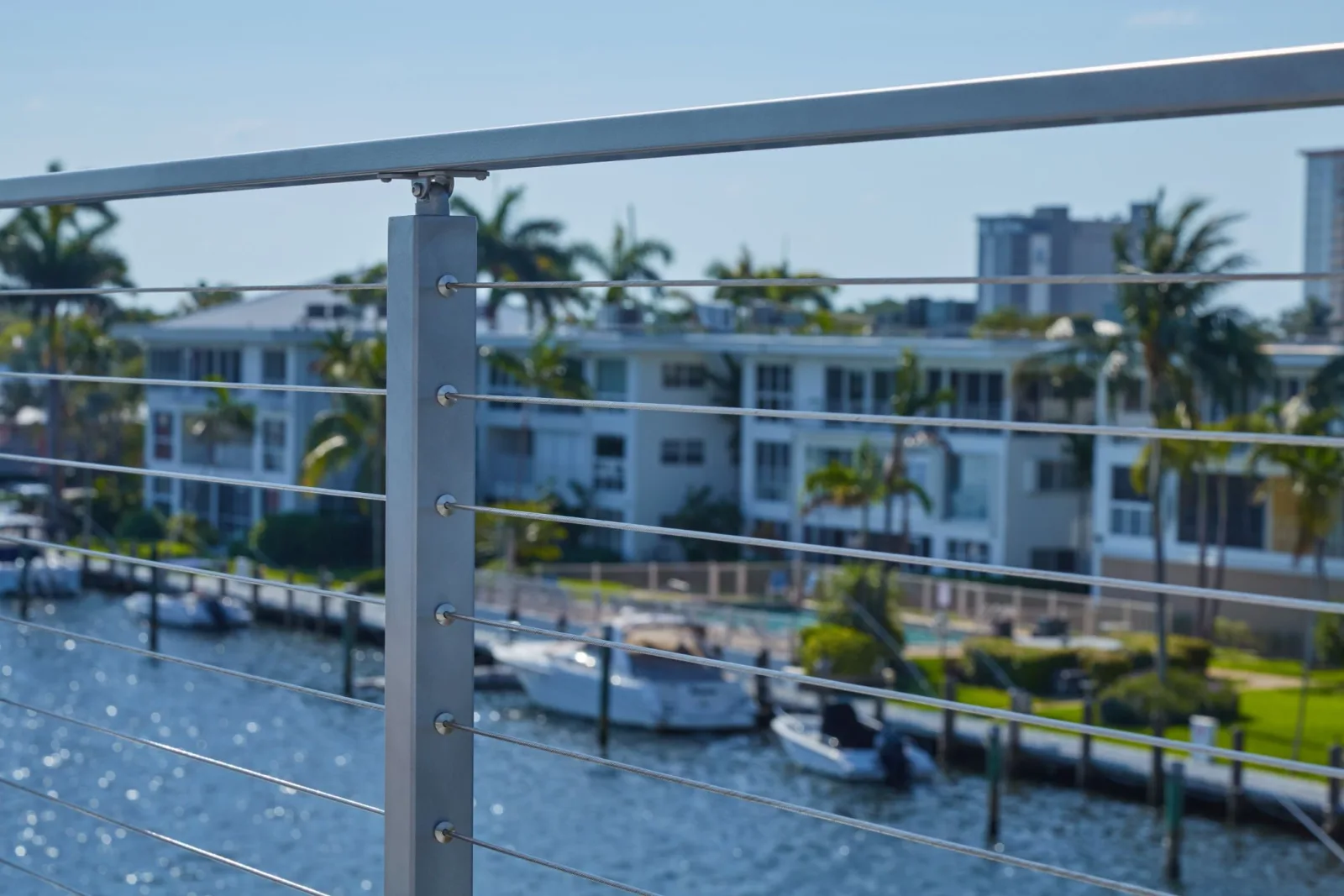Close view of a square post with waterway, docked boats and palms behind