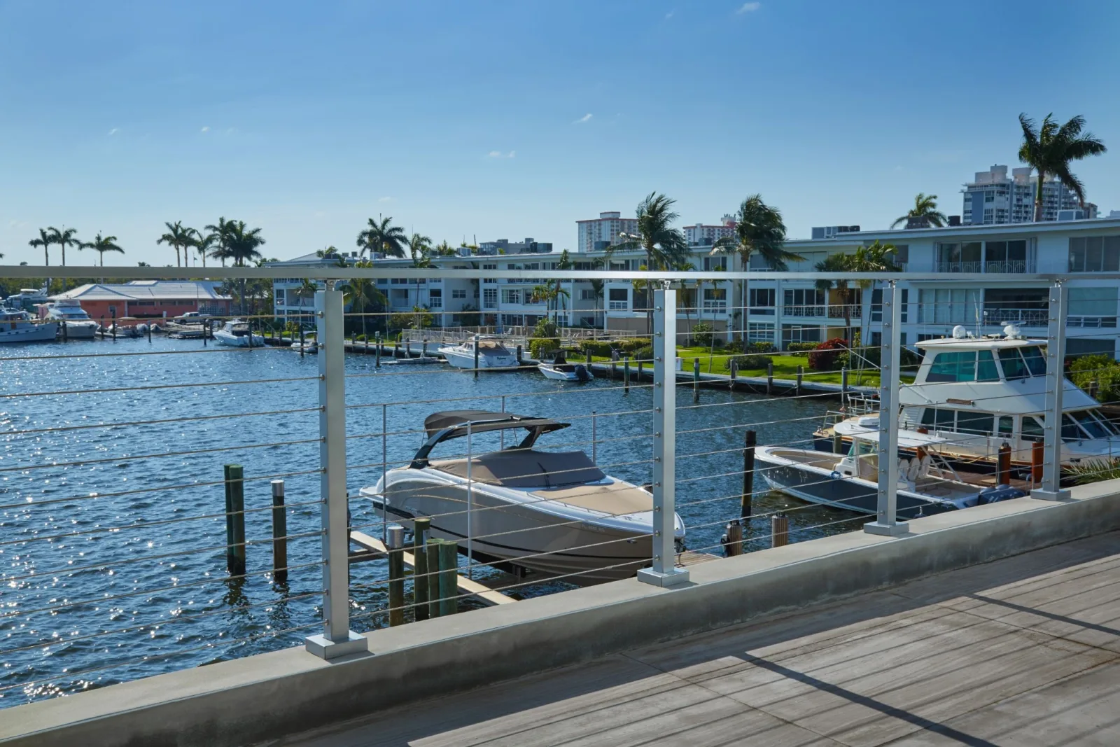 Waterfront deck railing above boat lifts and a row of docks