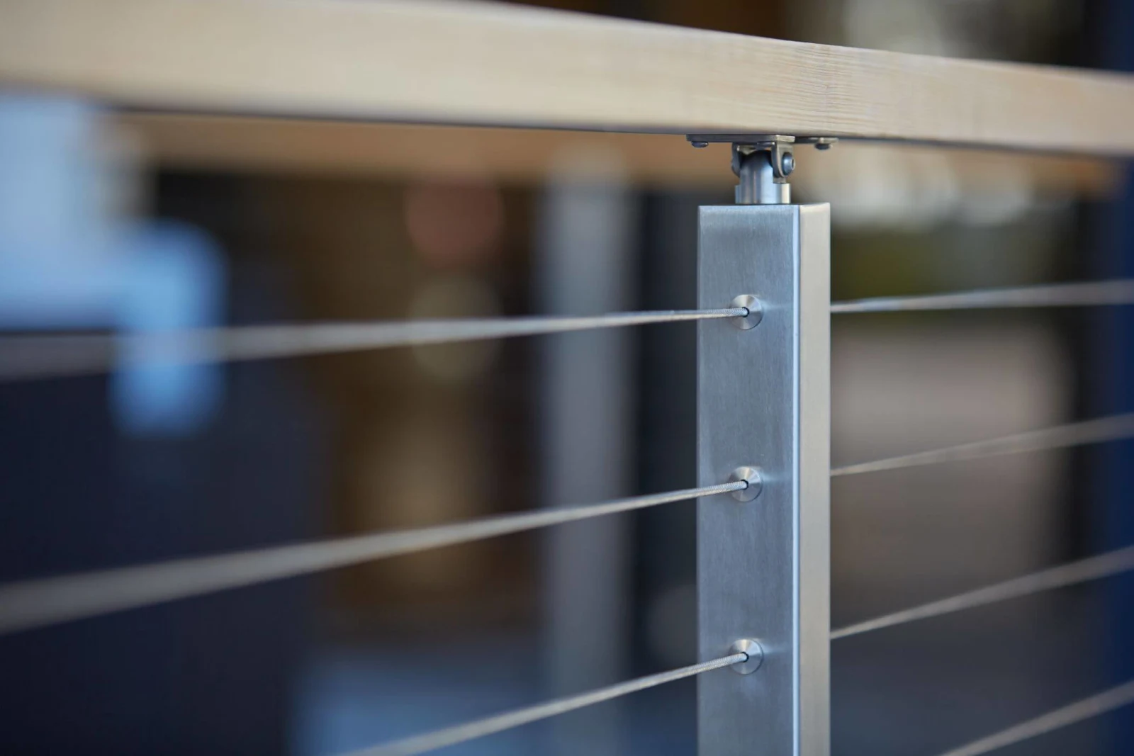 Tight detail of a post, cable fittings and the wood top rail above