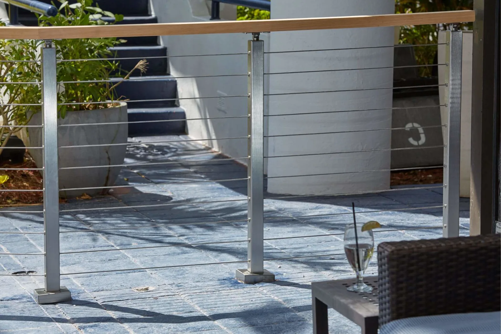 Patio railing on stone paving with posts base-mounted along a walkway