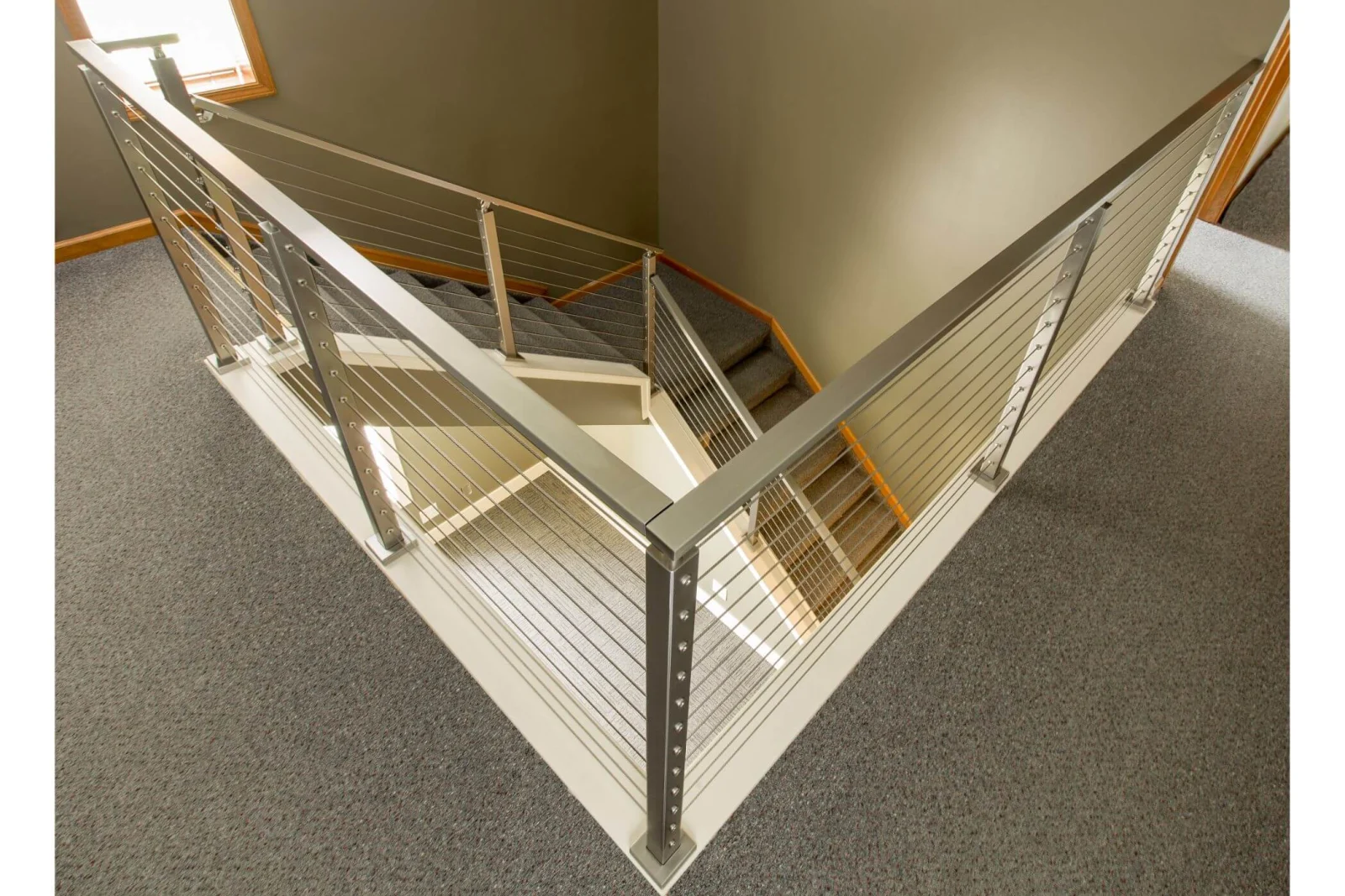 Overhead view of railing wrapping a stairwell opening on the upper floor