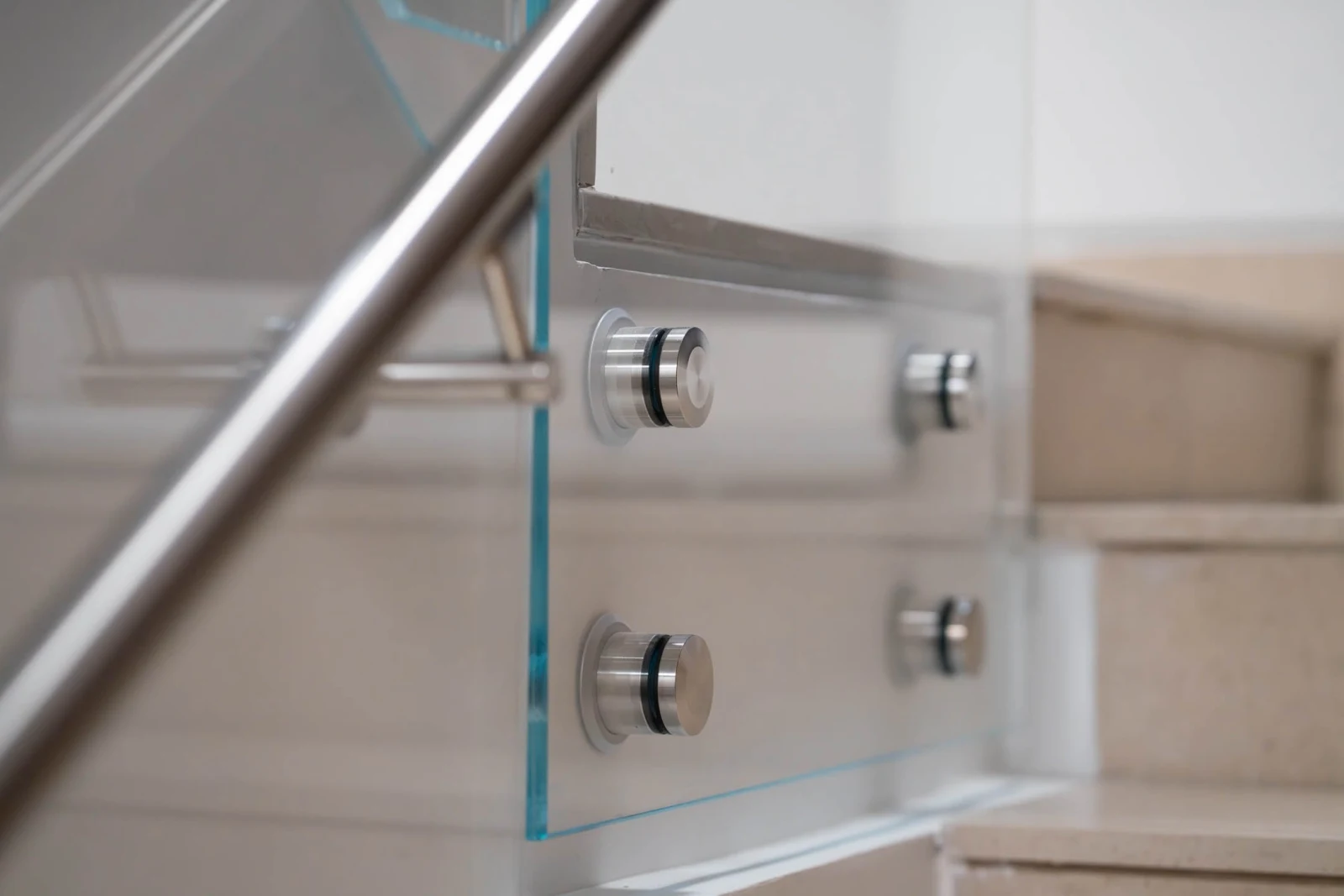 Close view of polished standoff discs holding a glass panel to the stringer