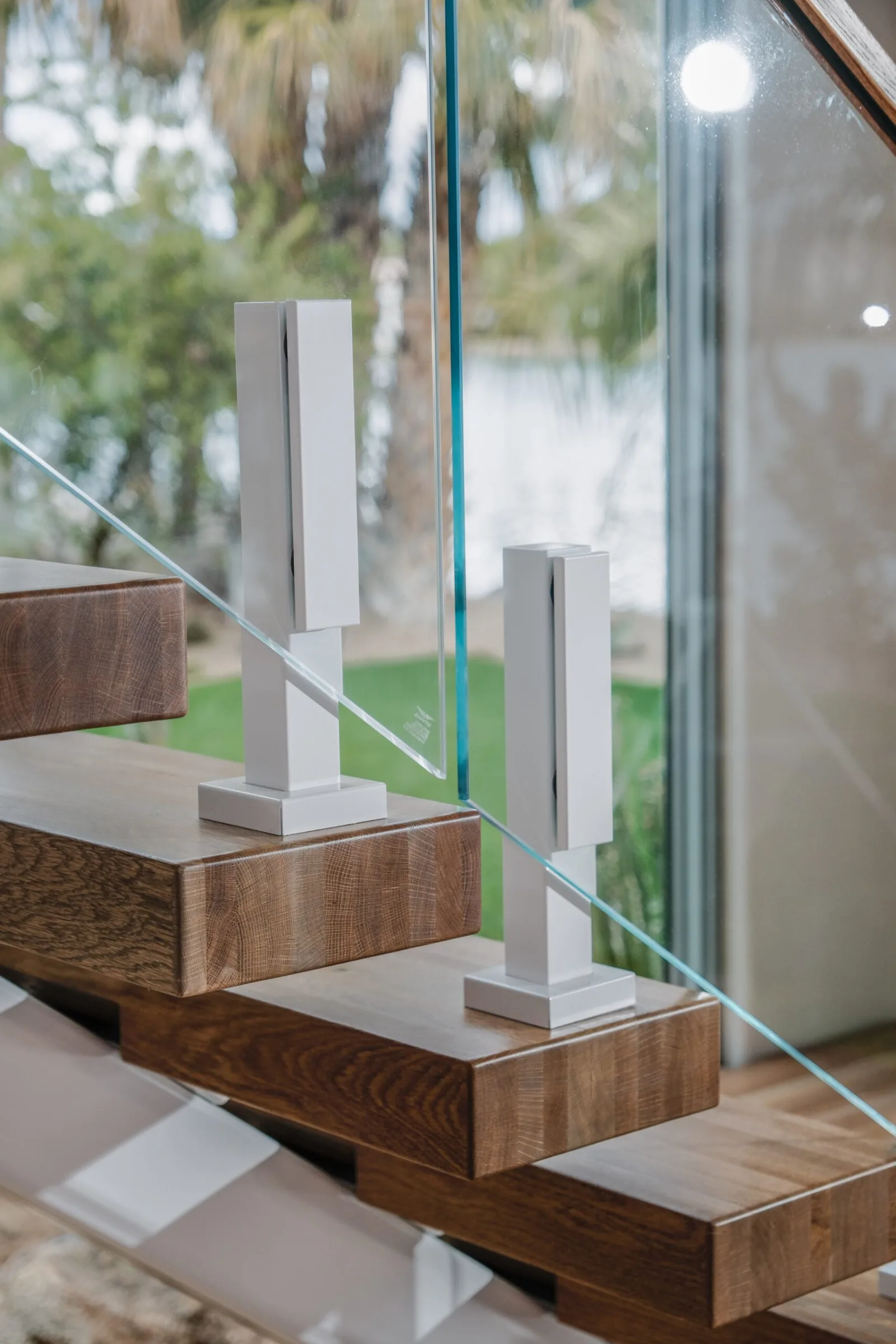 Close view of white glass clamps set into the edge of wood treads