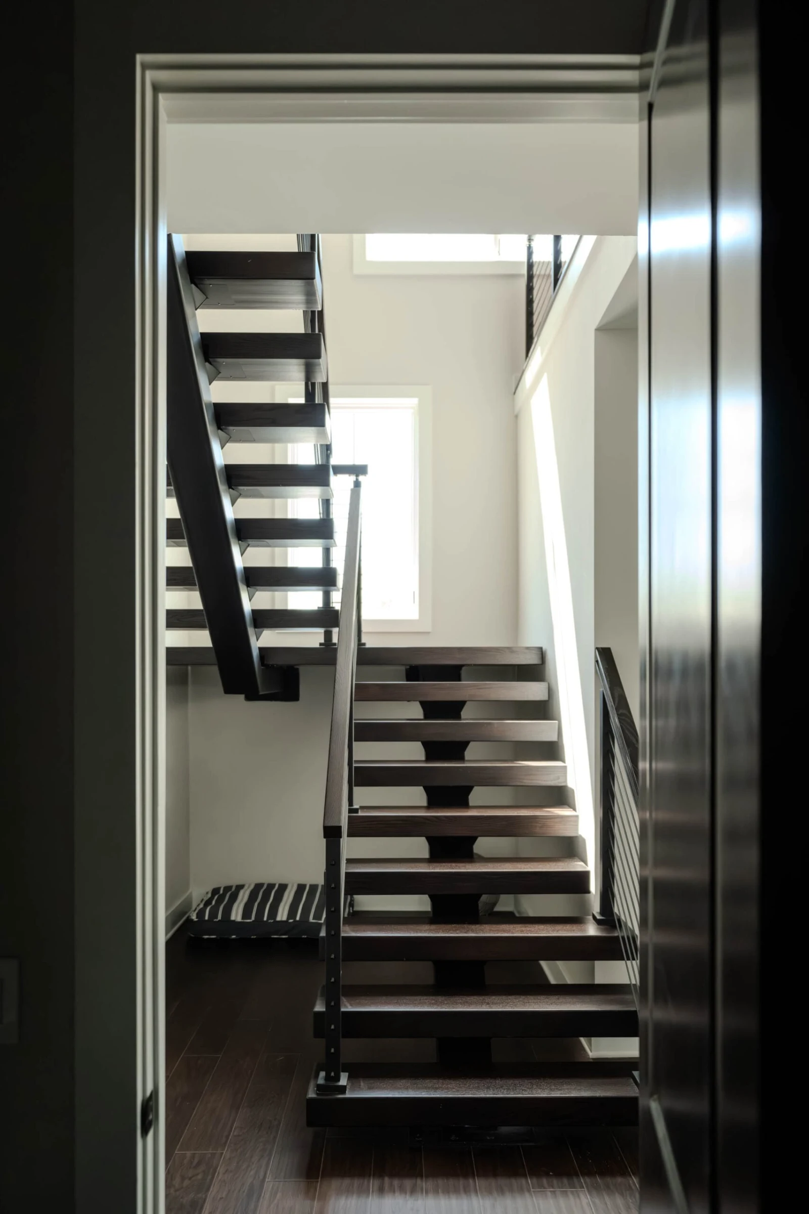 View through a doorway into the stairwell where two flights turn at a landing