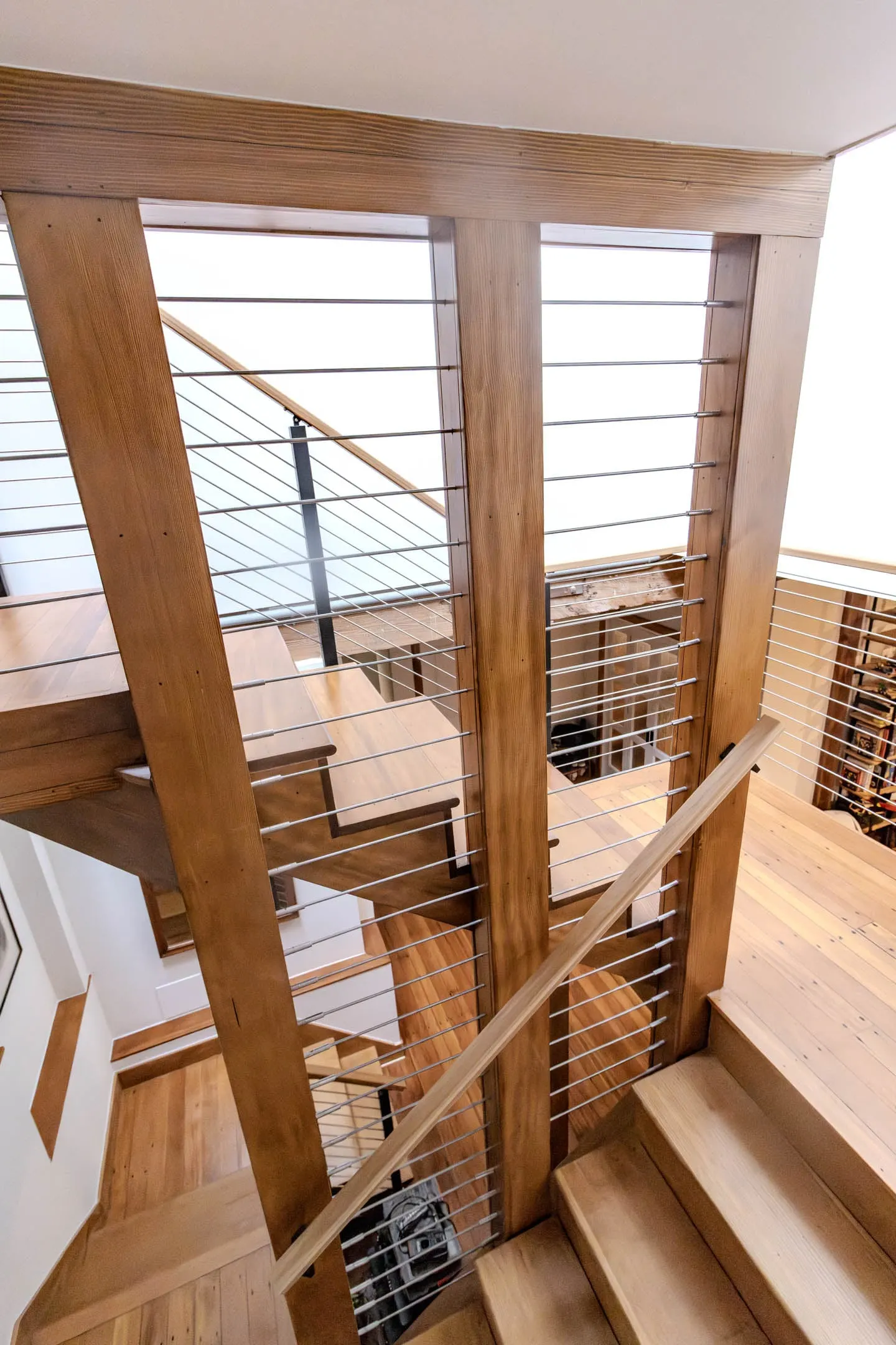 Overhead view of the switchback stairwell, wood posts and horizontal rod infill