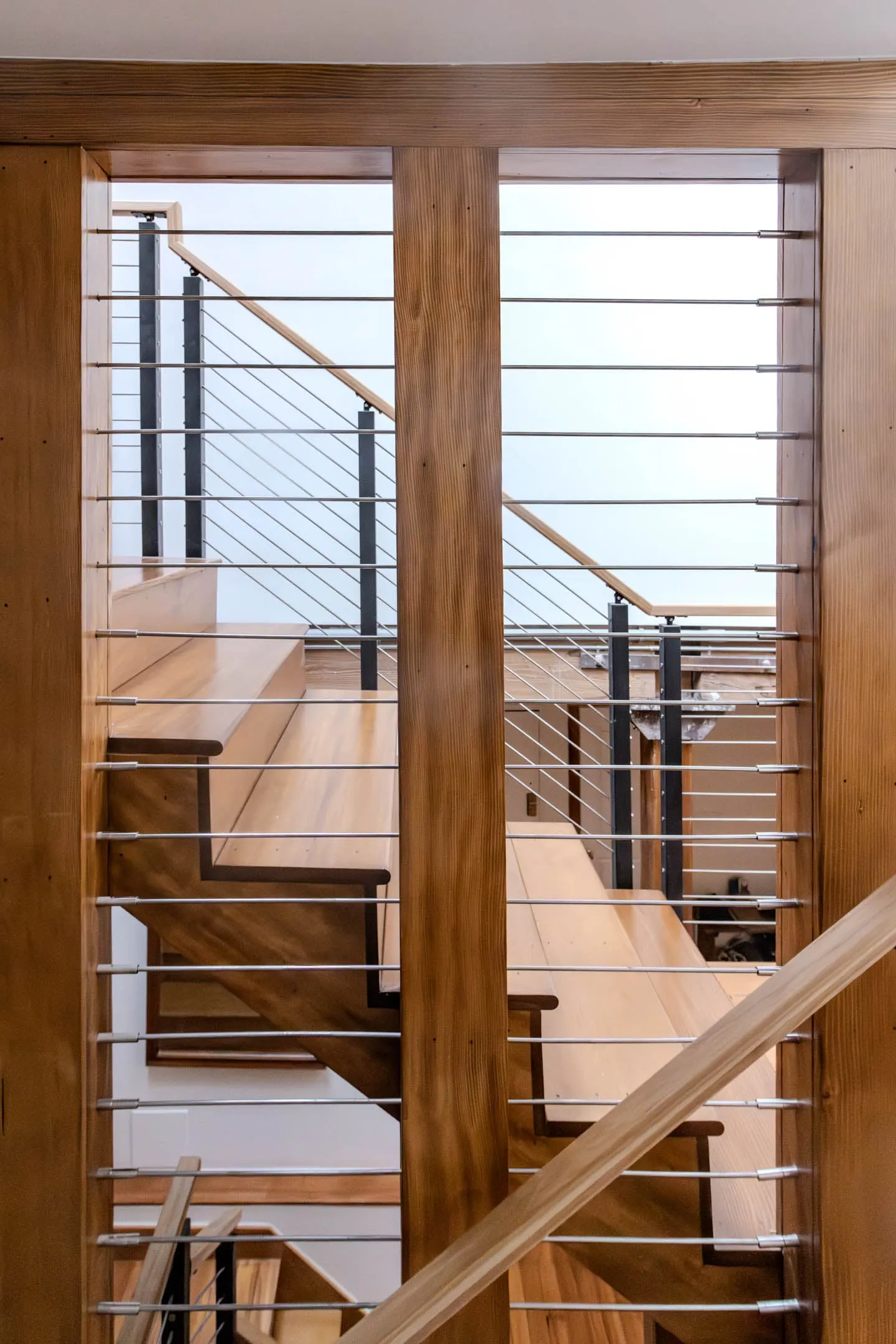 Two flights seen through a framed opening, black posts carrying horizontal rods