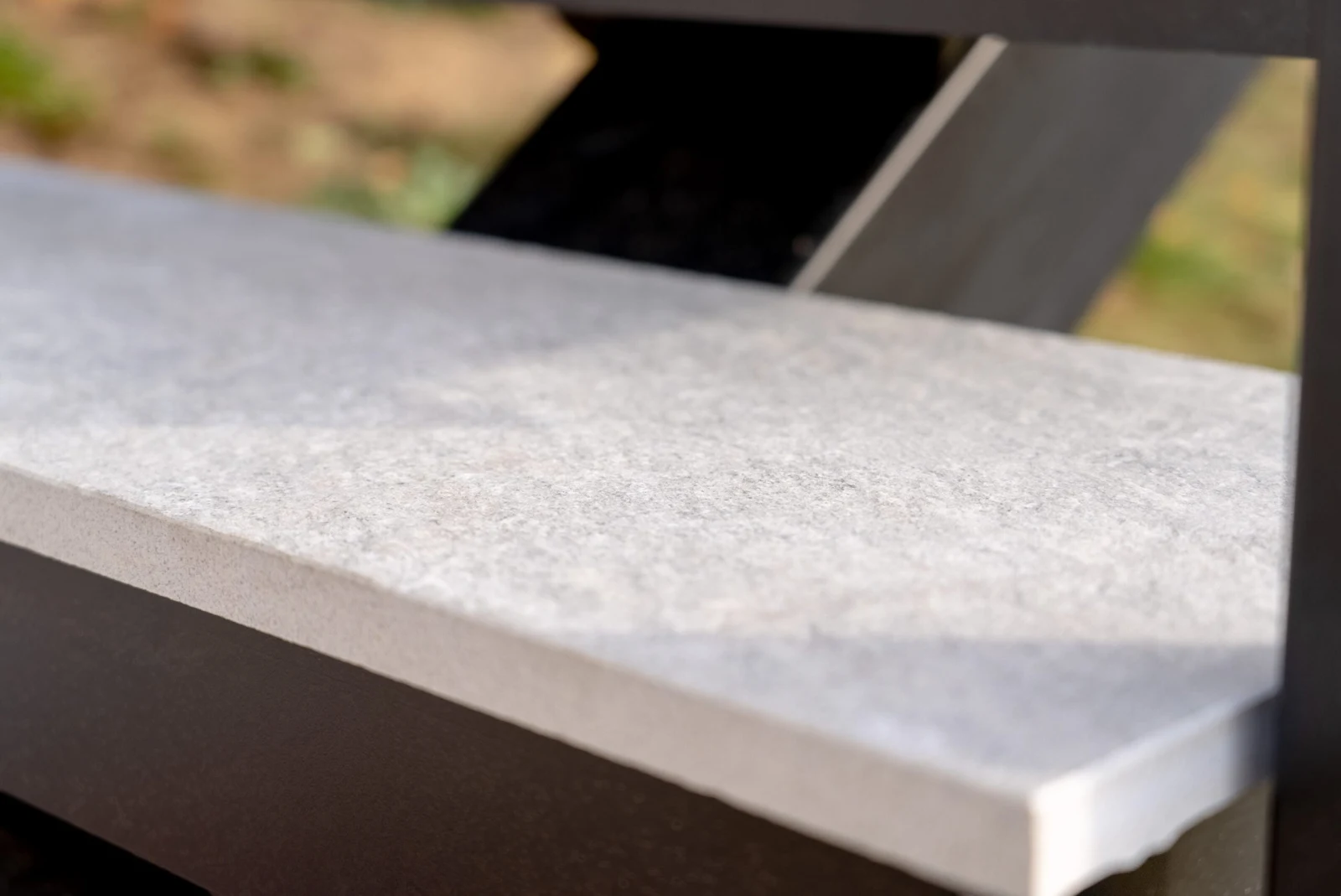 Macro of a textured stone tread edge resting on the black frame