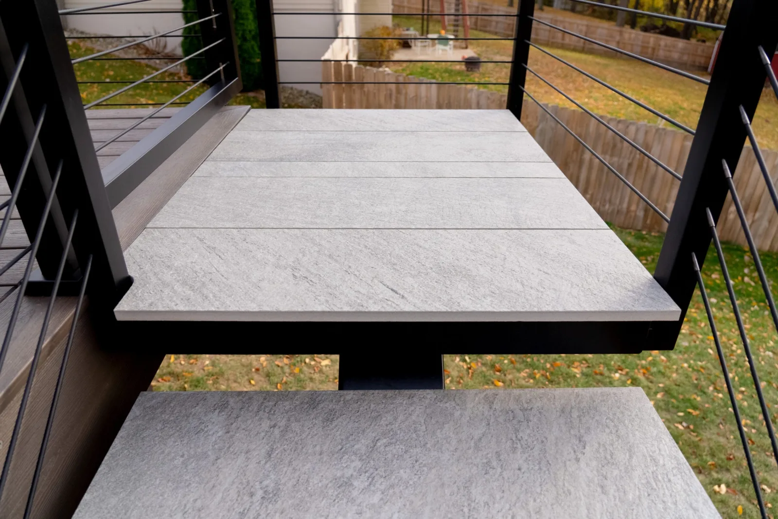 Looking down onto the pale stone landing and treads set on black steel
