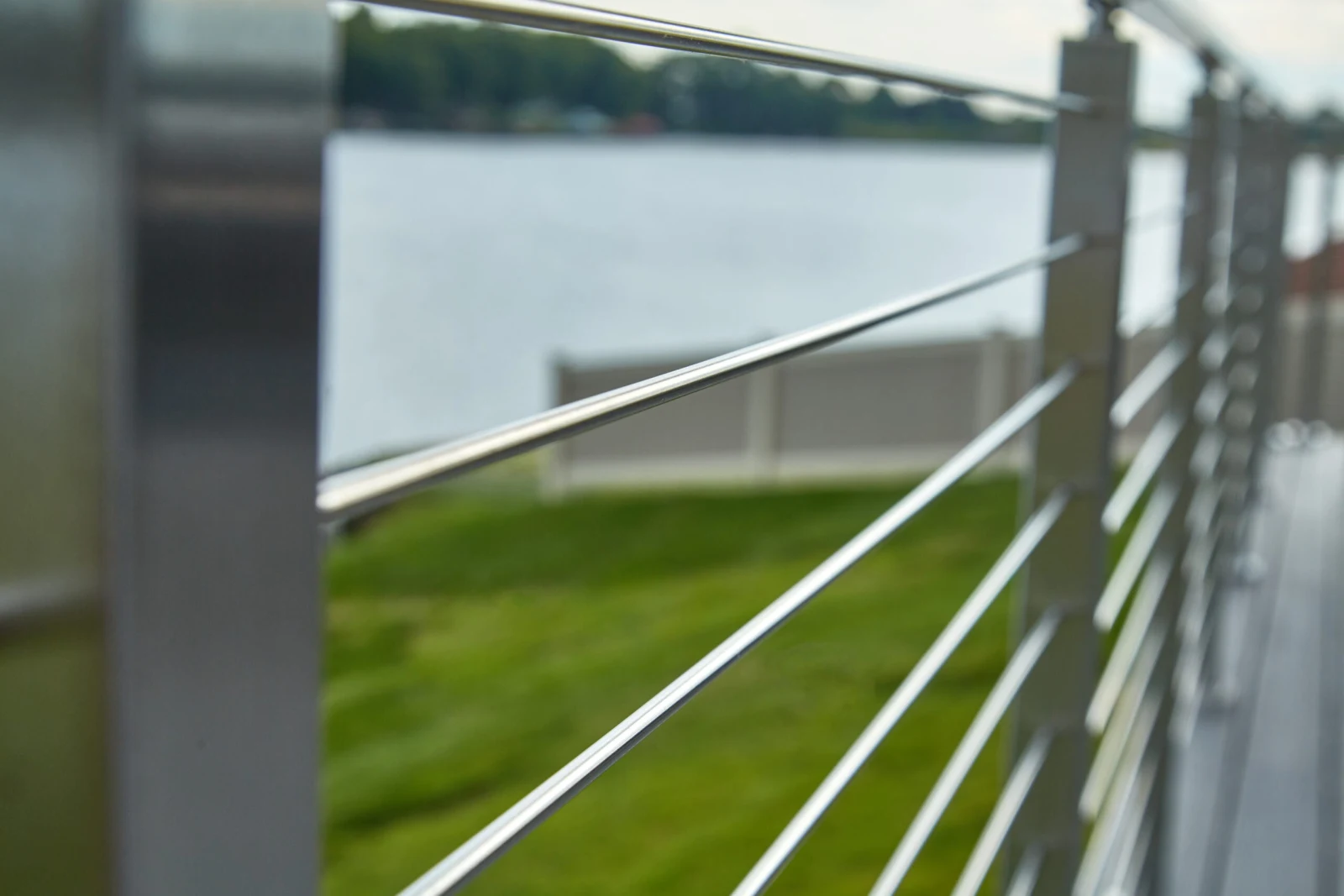 Tight perspective down the top rail as rods recede along the waterfront
