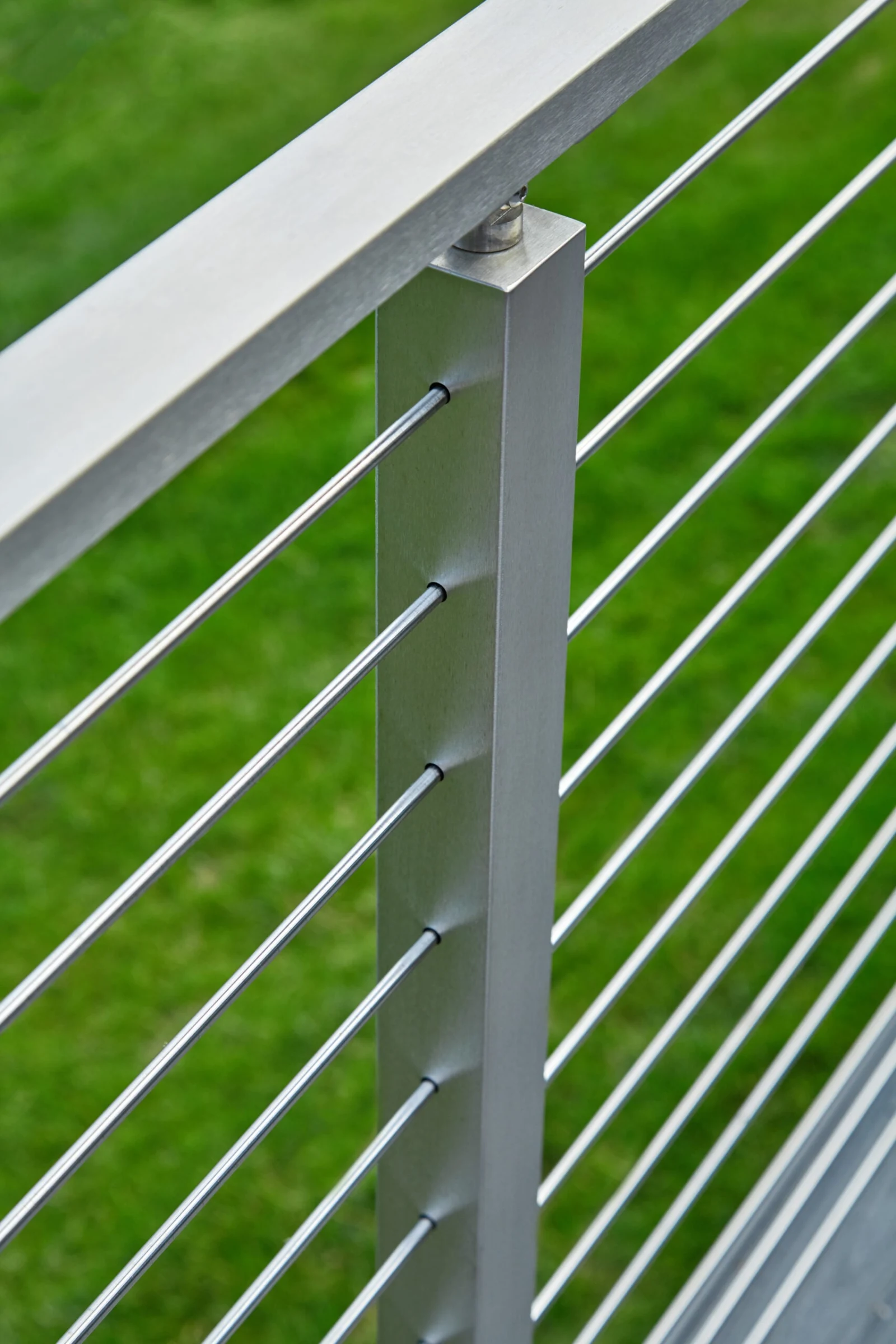 Angled look along the top rail as rods fan out over green lawn