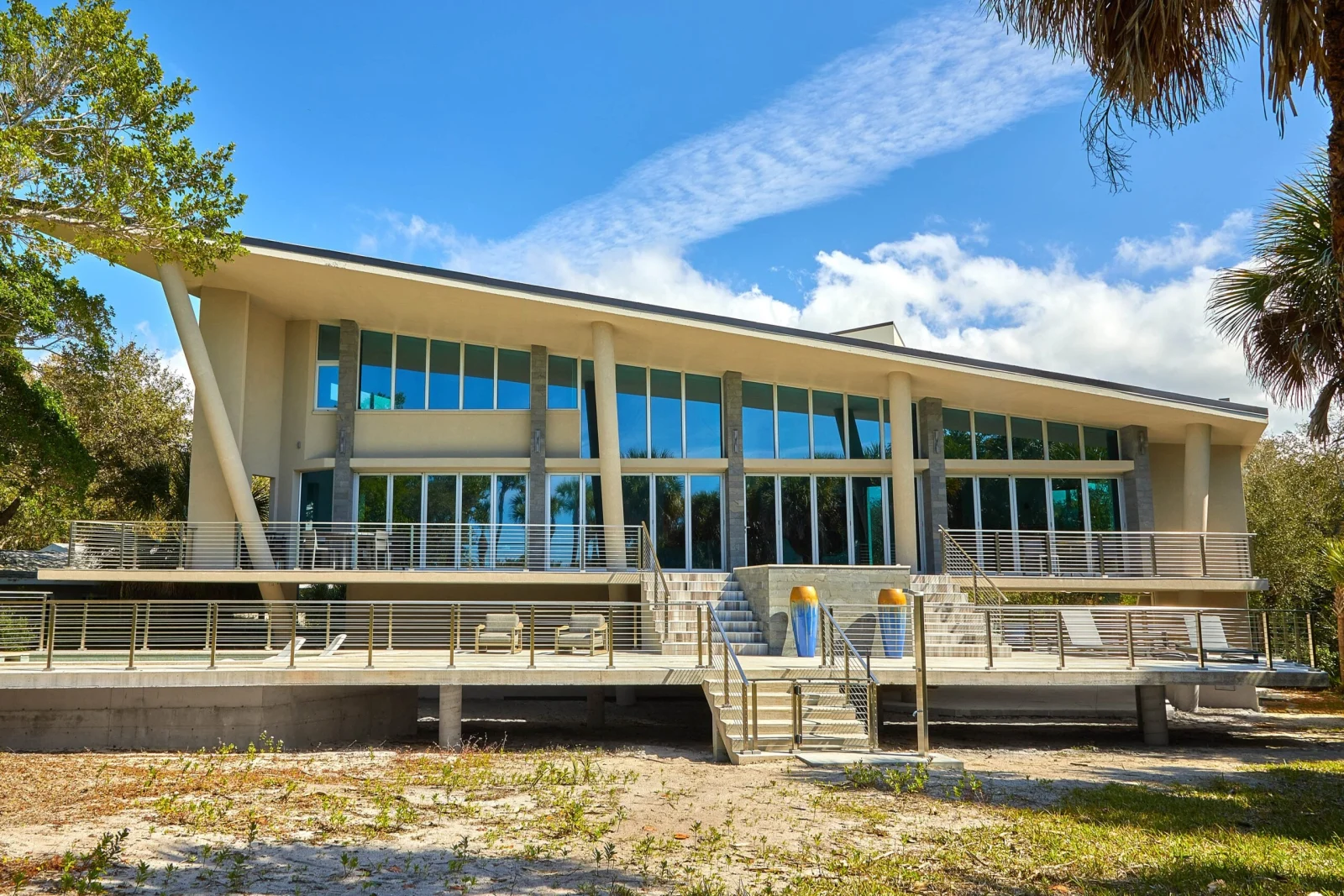 Wide view of a coastal home with rod railing spanning two deck levels