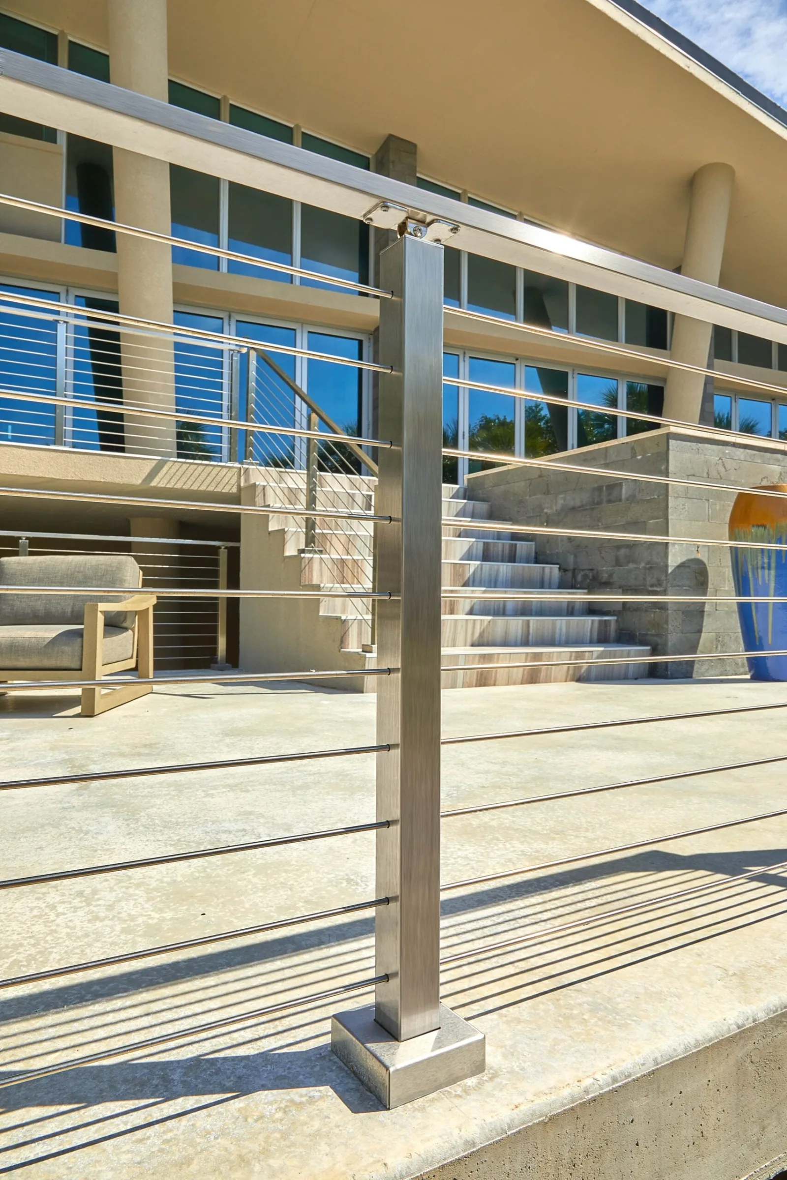 Square stainless post and horizontal rods close up on a sunlit terrace