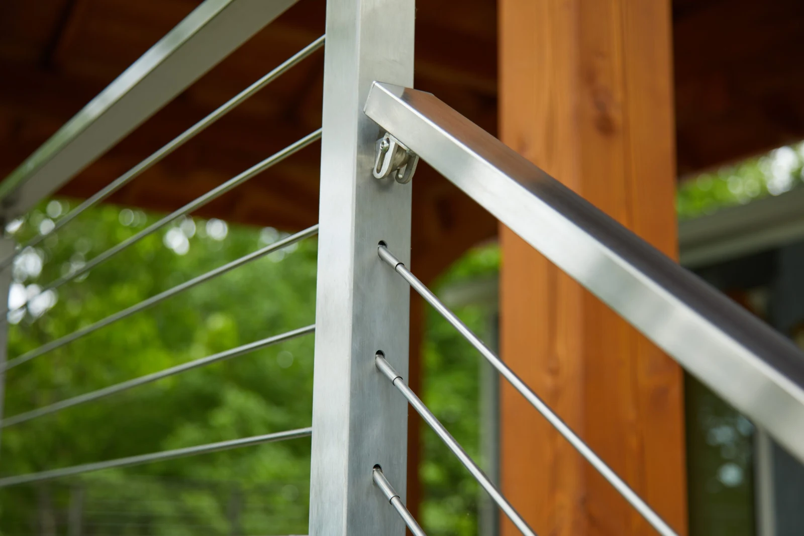 Close view of a post cap where flat top rail meets horizontal rods