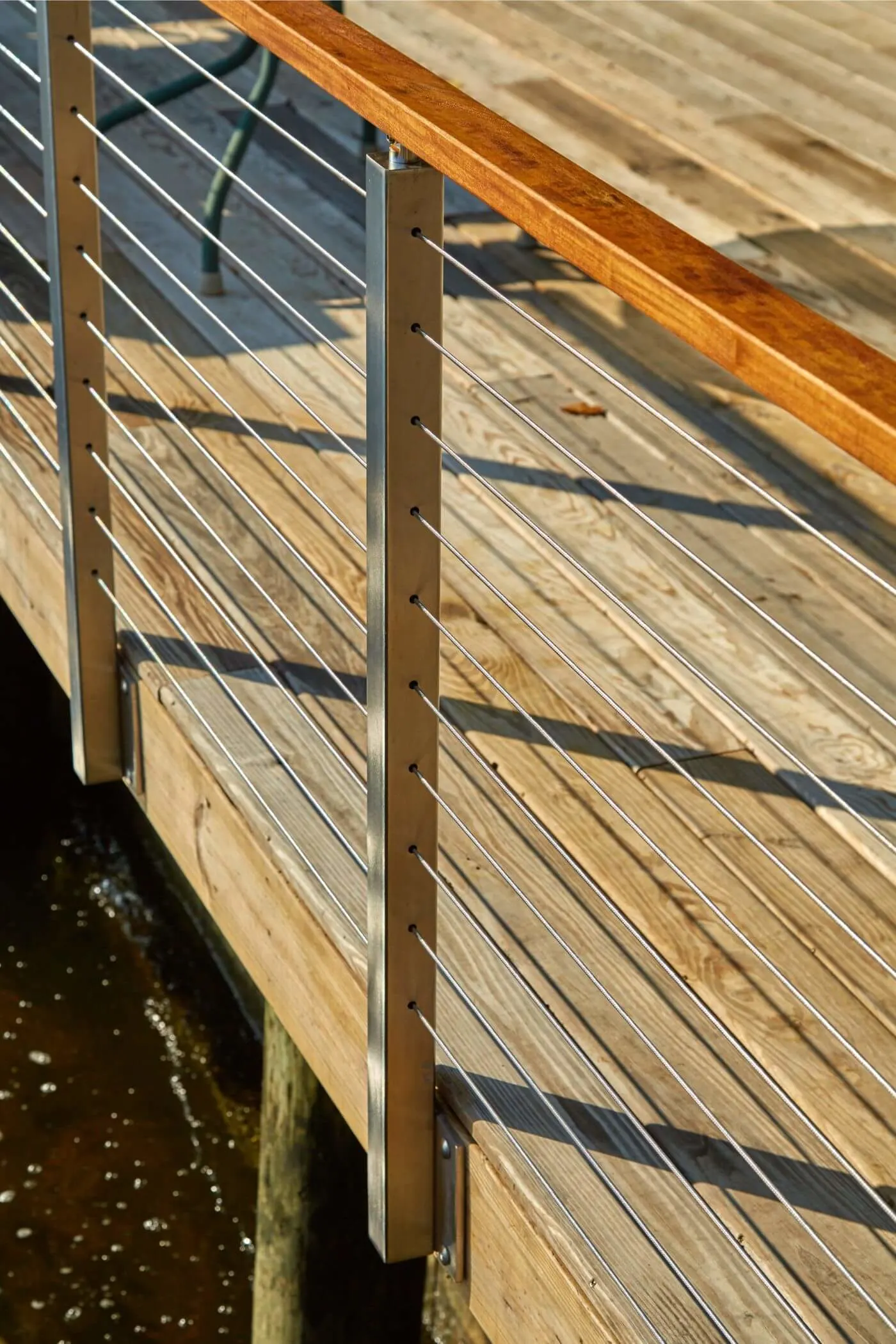 Side-mounted posts and horizontal rods running the length of a wooden pier